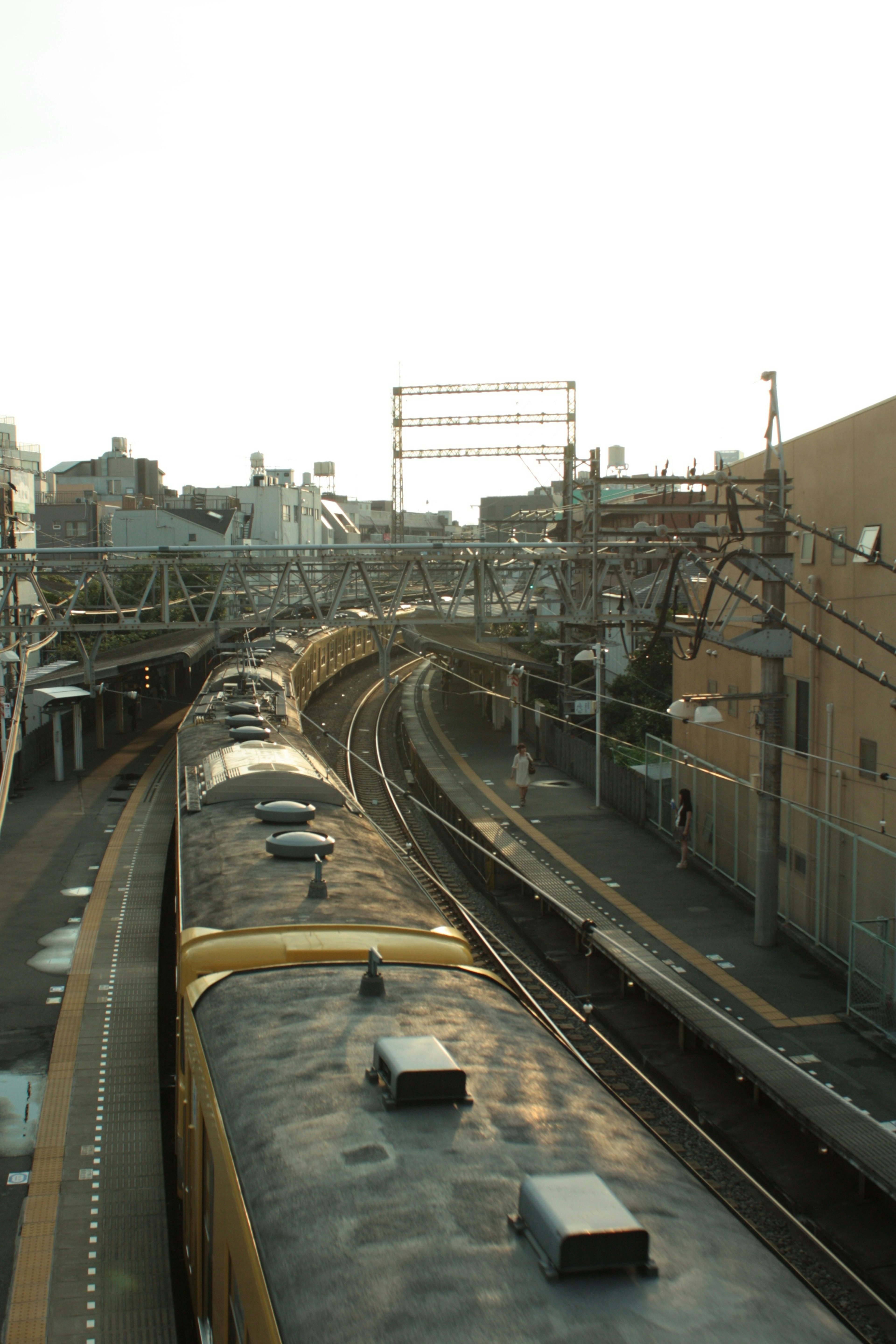 ทิวทัศน์ทางรถไฟในเมืองที่โค้งเห็นรางรถไฟและอาคารรอบข้าง