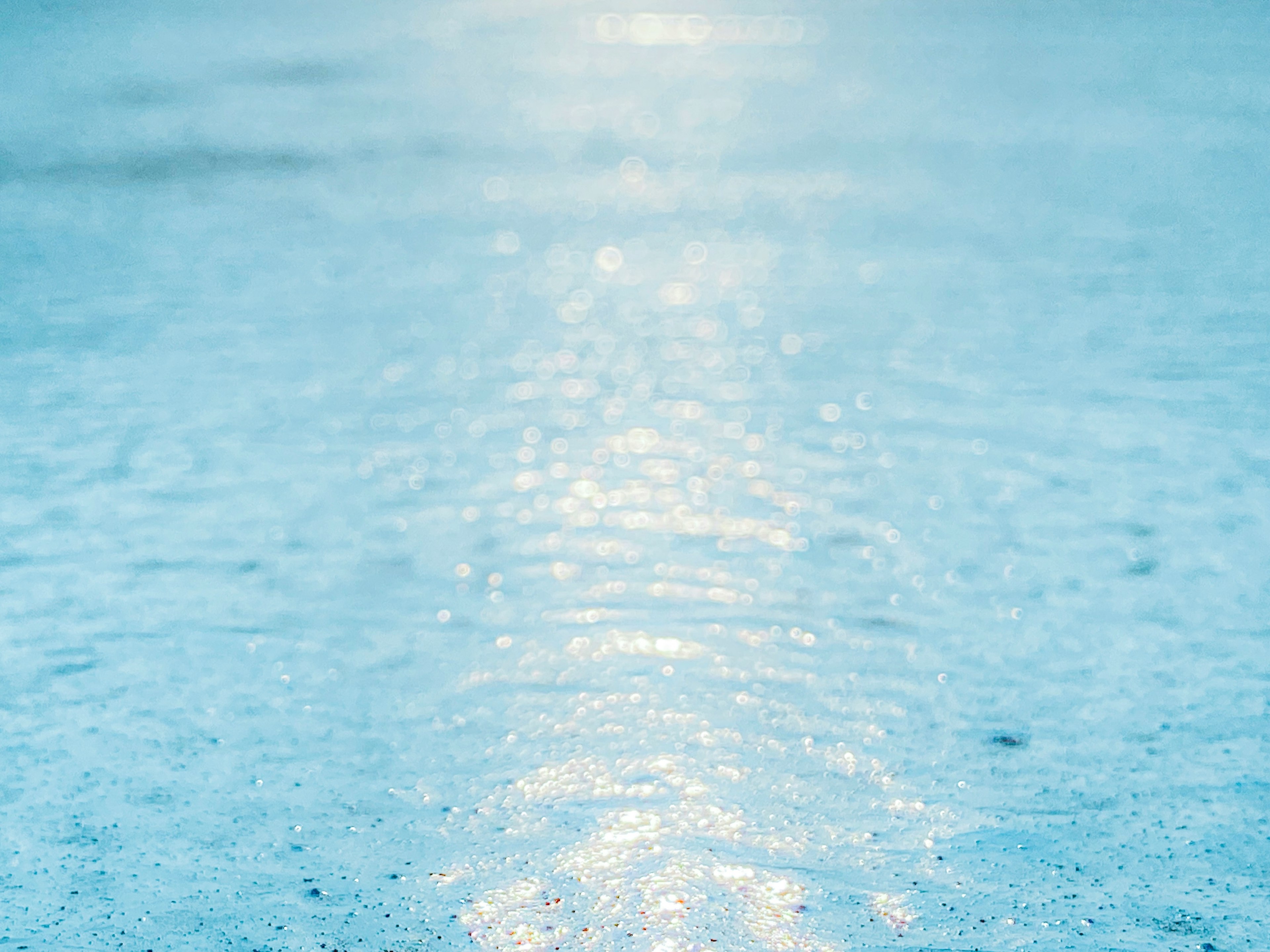 青い水面に光が反射する静かな景色