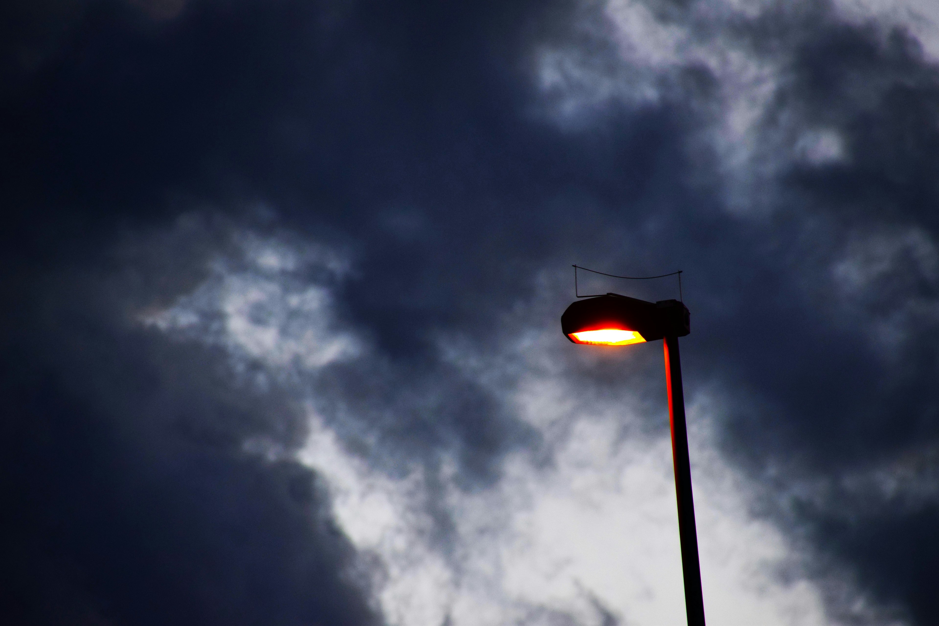 Nahaufnahme einer beleuchteten Straßenlaterne vor einem dunklen Himmel