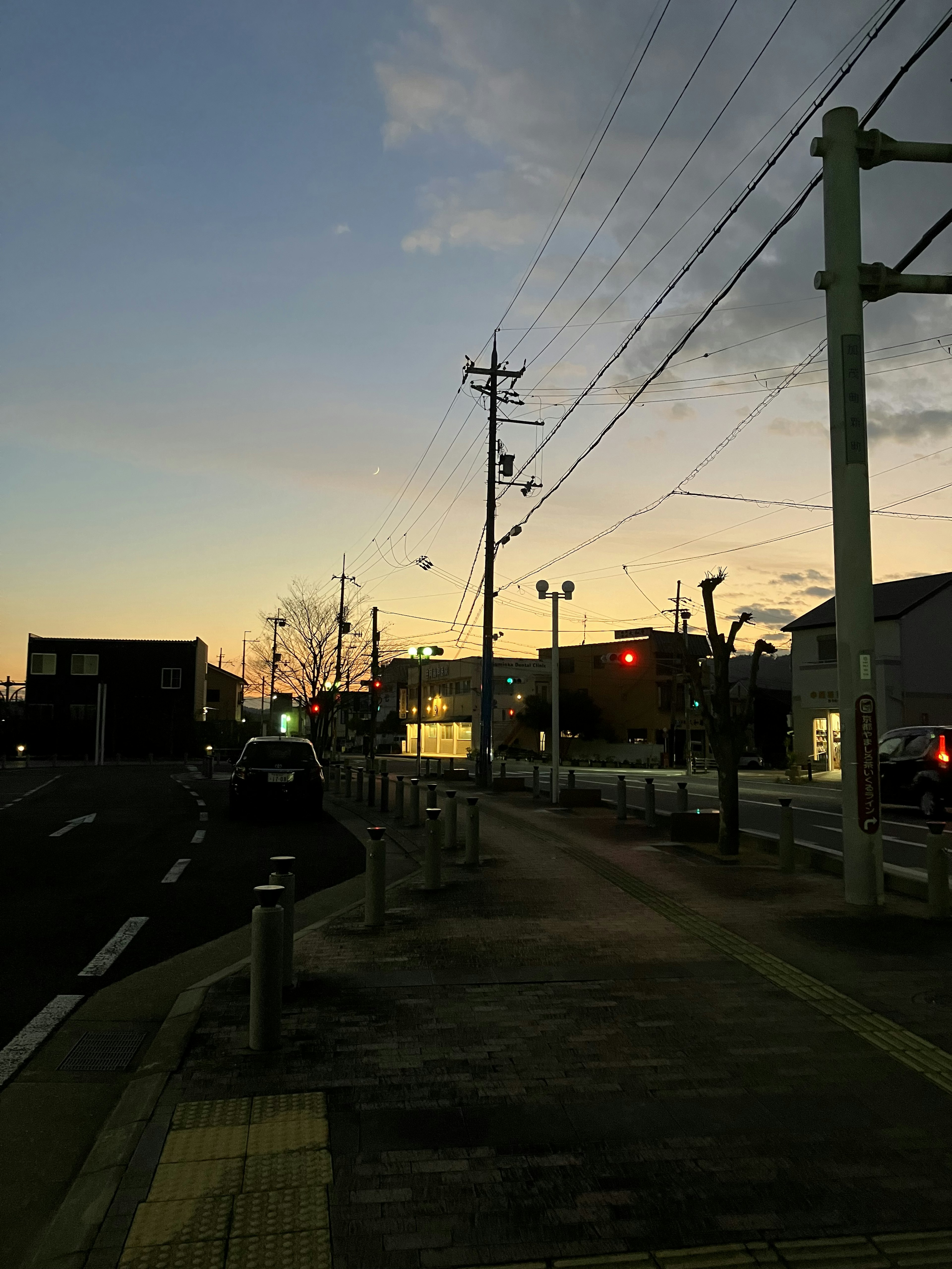 夕暮れの街道に沿った歩道と電柱の風景