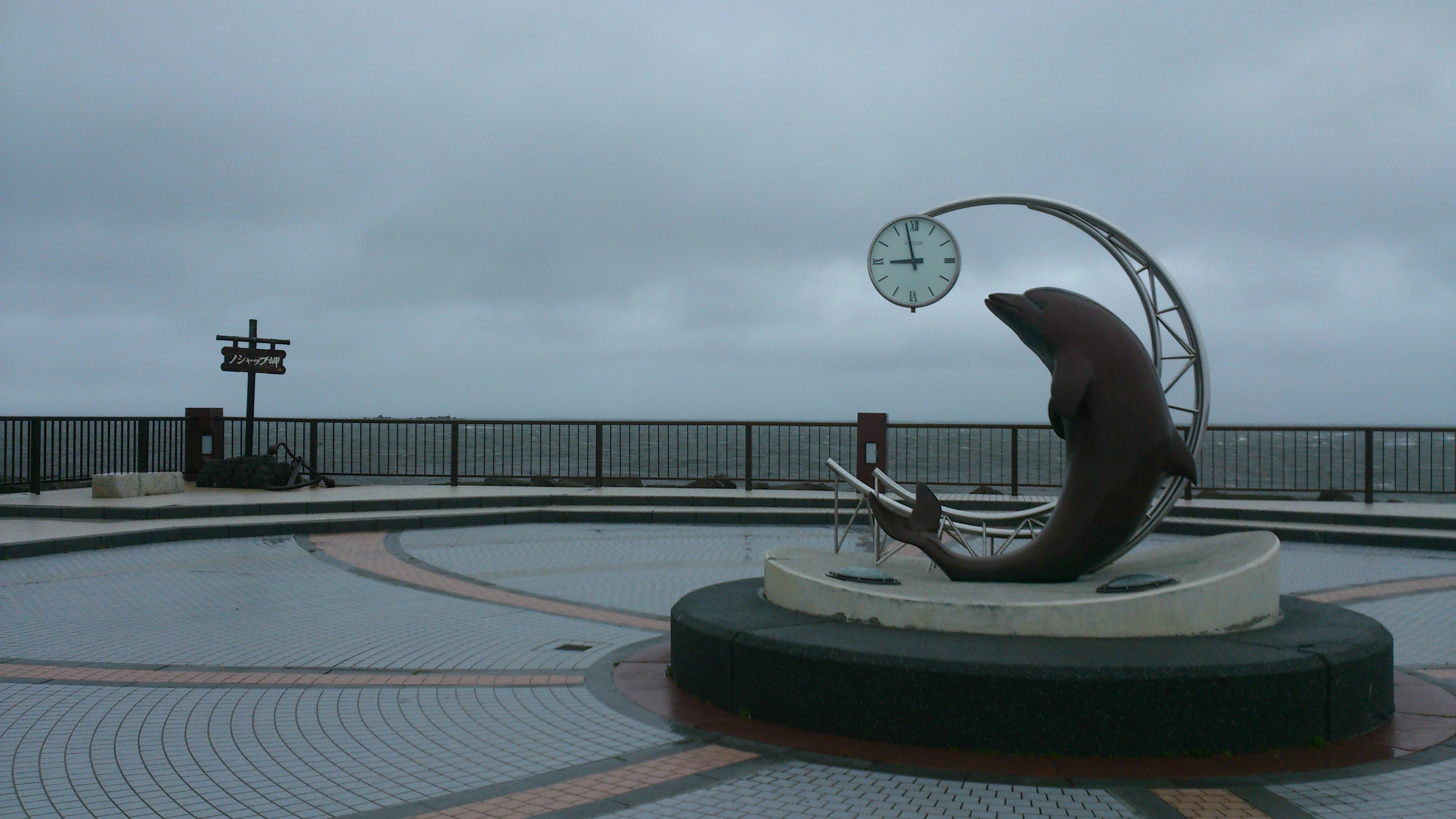 Sculpture de dauphin et monument horloge au bord de la mer