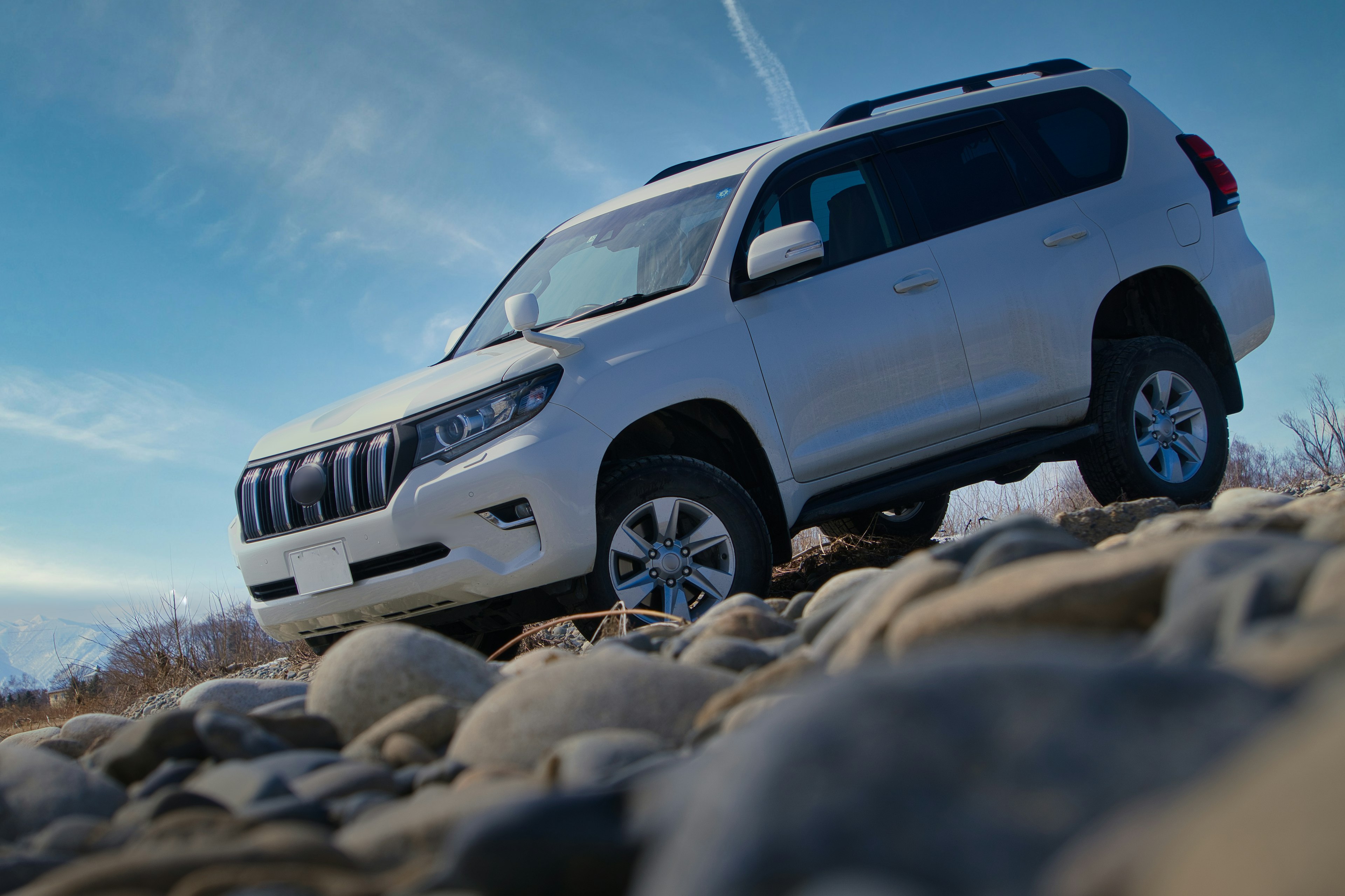 Un SUV blanco estacionado en un terreno rocoso