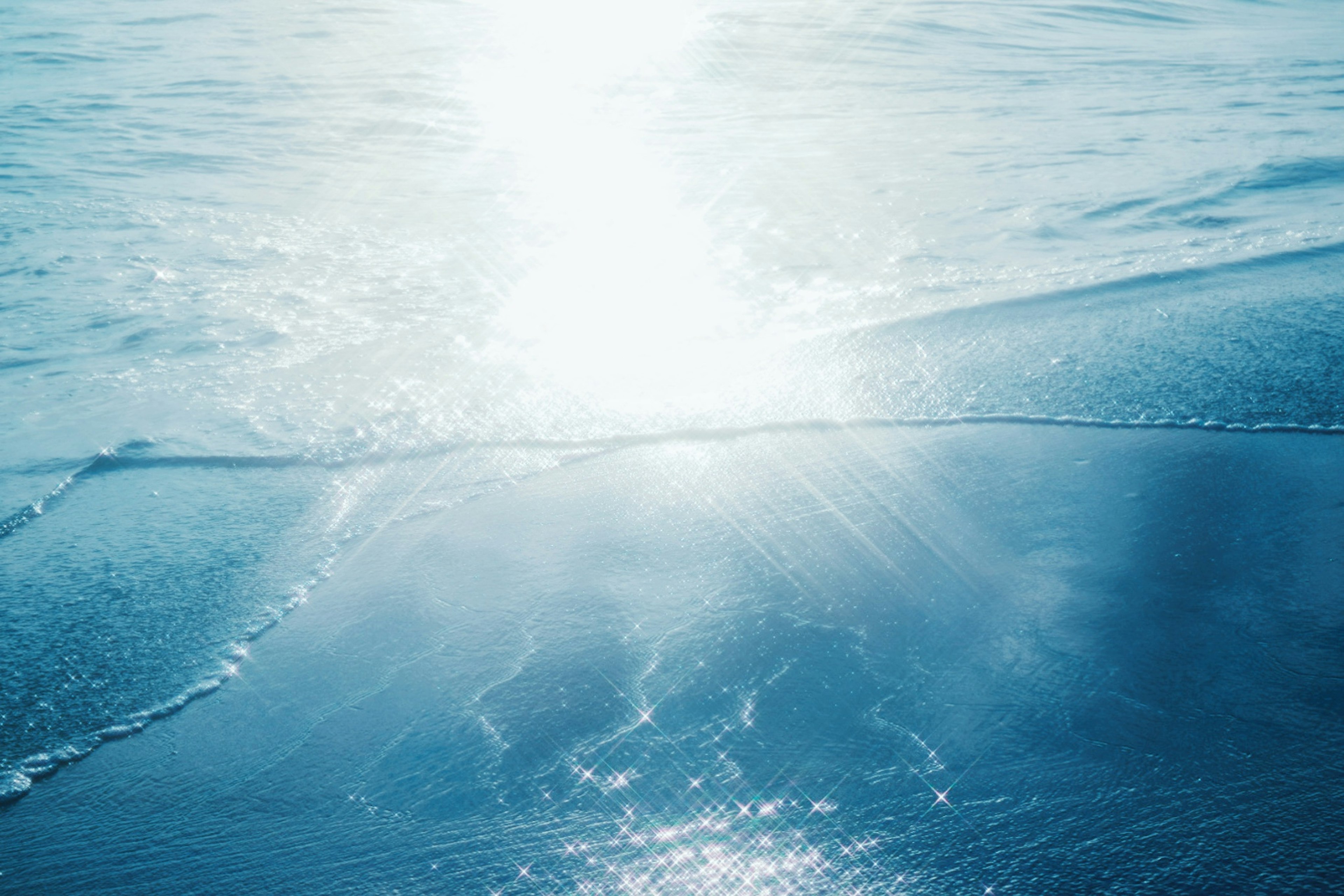 Reflections of light on blue ocean surface and gentle waves