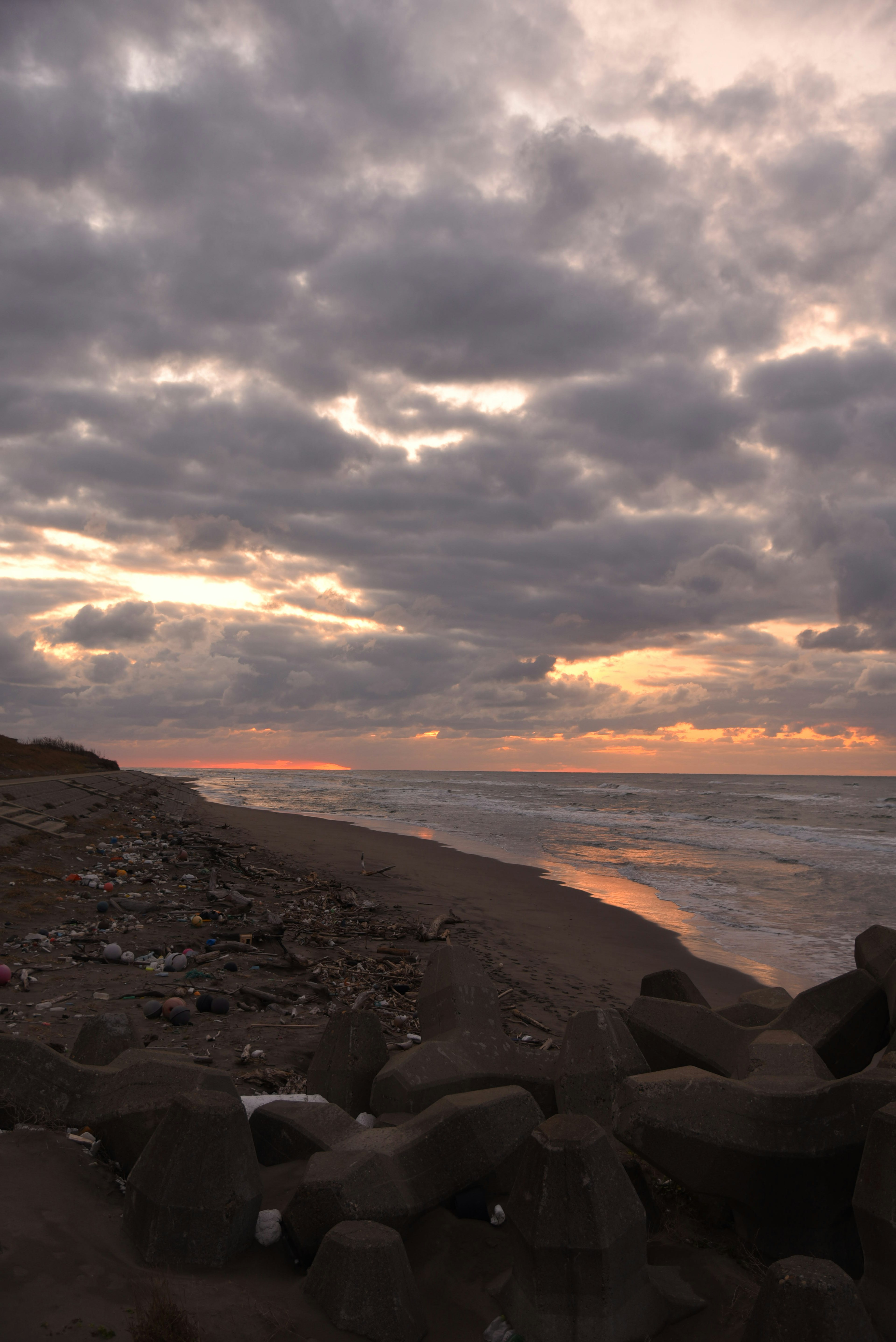 Paesaggio di spiaggia al tramonto con nuvole ampie e onde gentili