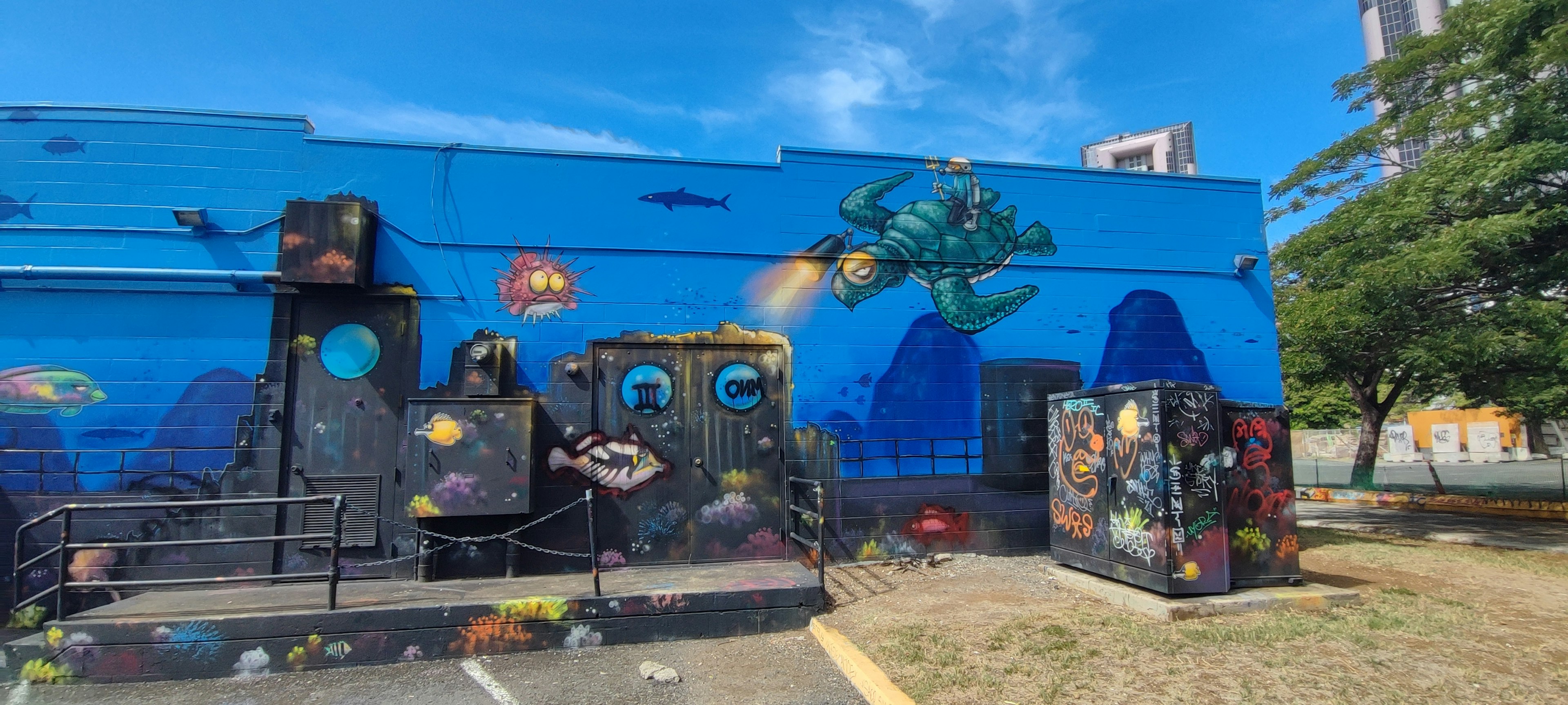 Ocean-themed graffiti on a blue wall featuring marine life