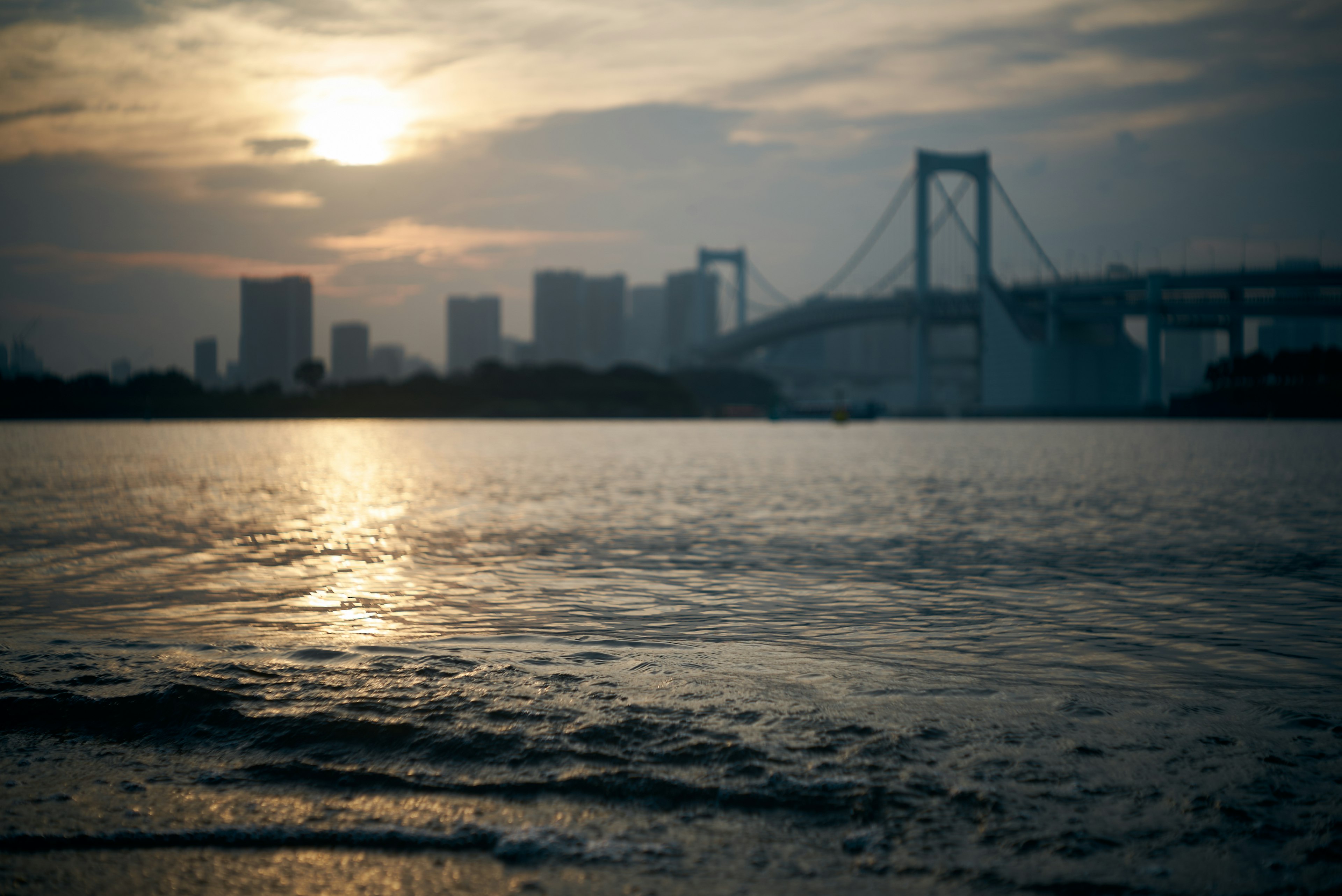 Sunset view over Tokyo Bay featuring Rainbow Bridge and city skyline