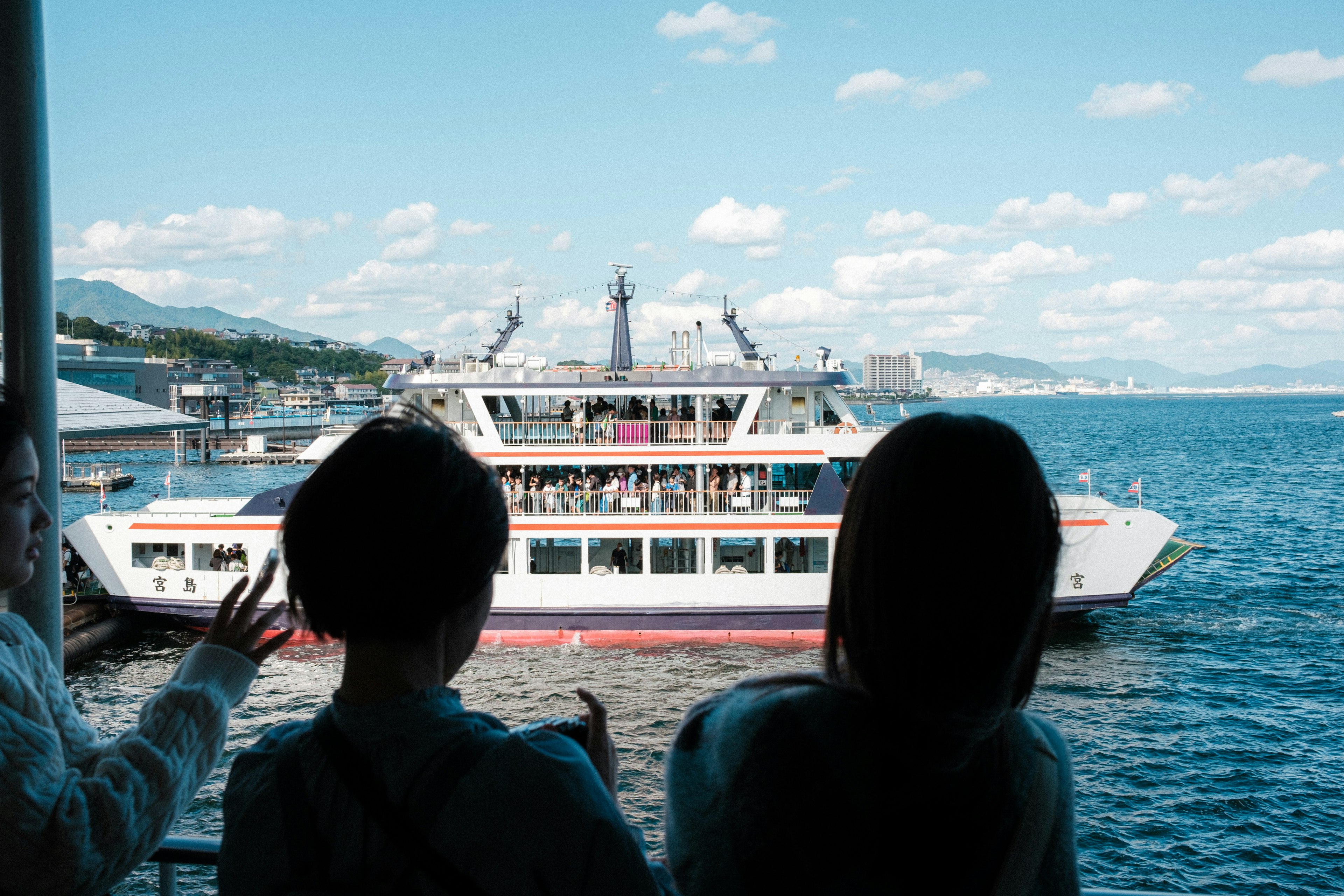 Silhouette de deux personnes regardant un ferry sur la mer