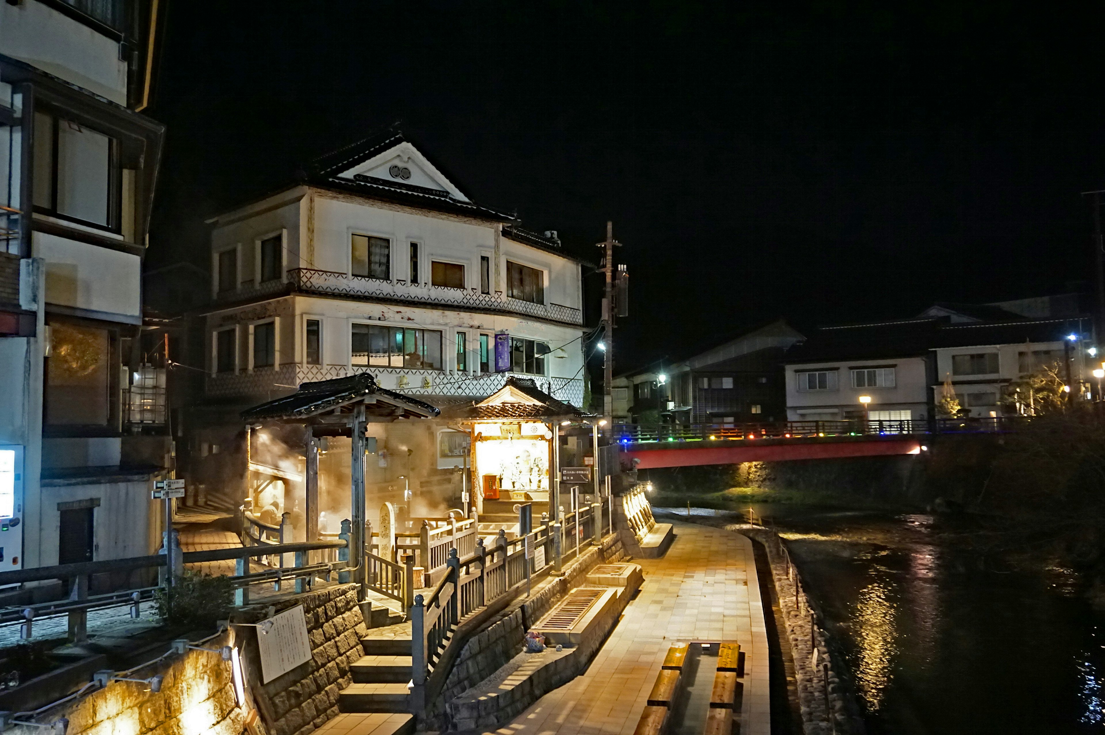 Night view of a hot spring town with buildings and a river