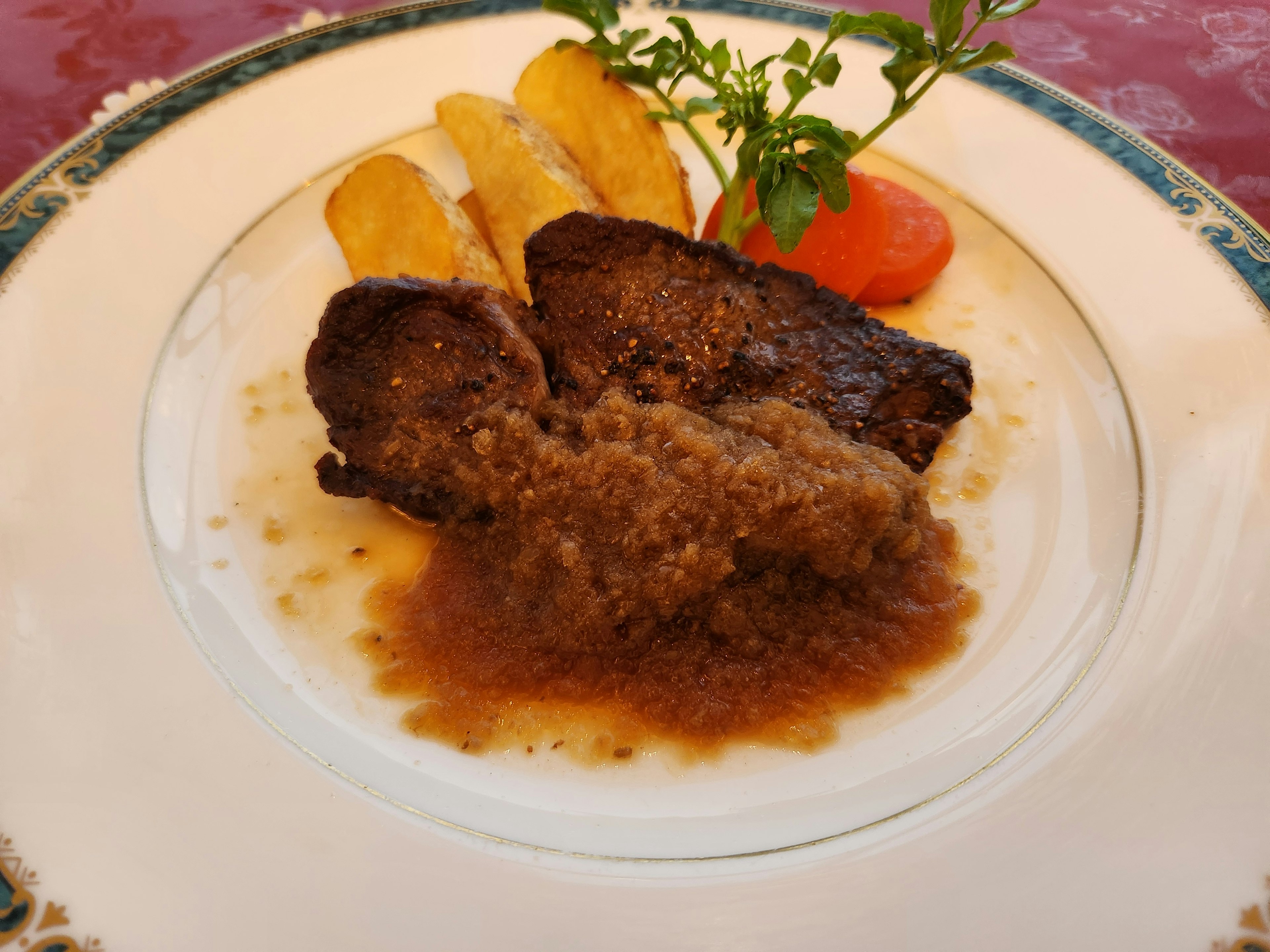 Un delizioso piatto di carne servito su un piatto bianco con contorni di verdure e salsa