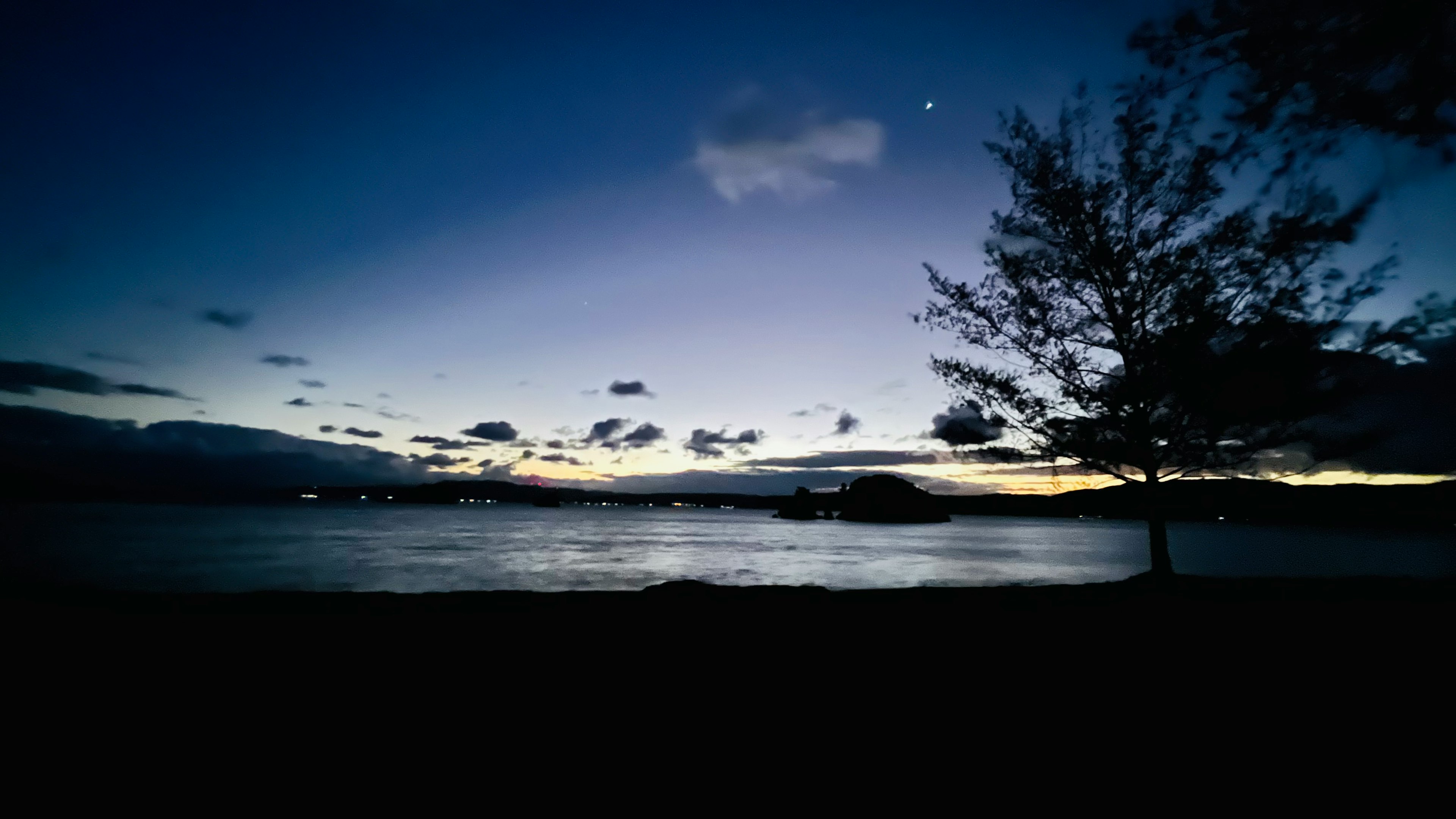 夜の湖畔の風景と星空のシルエット