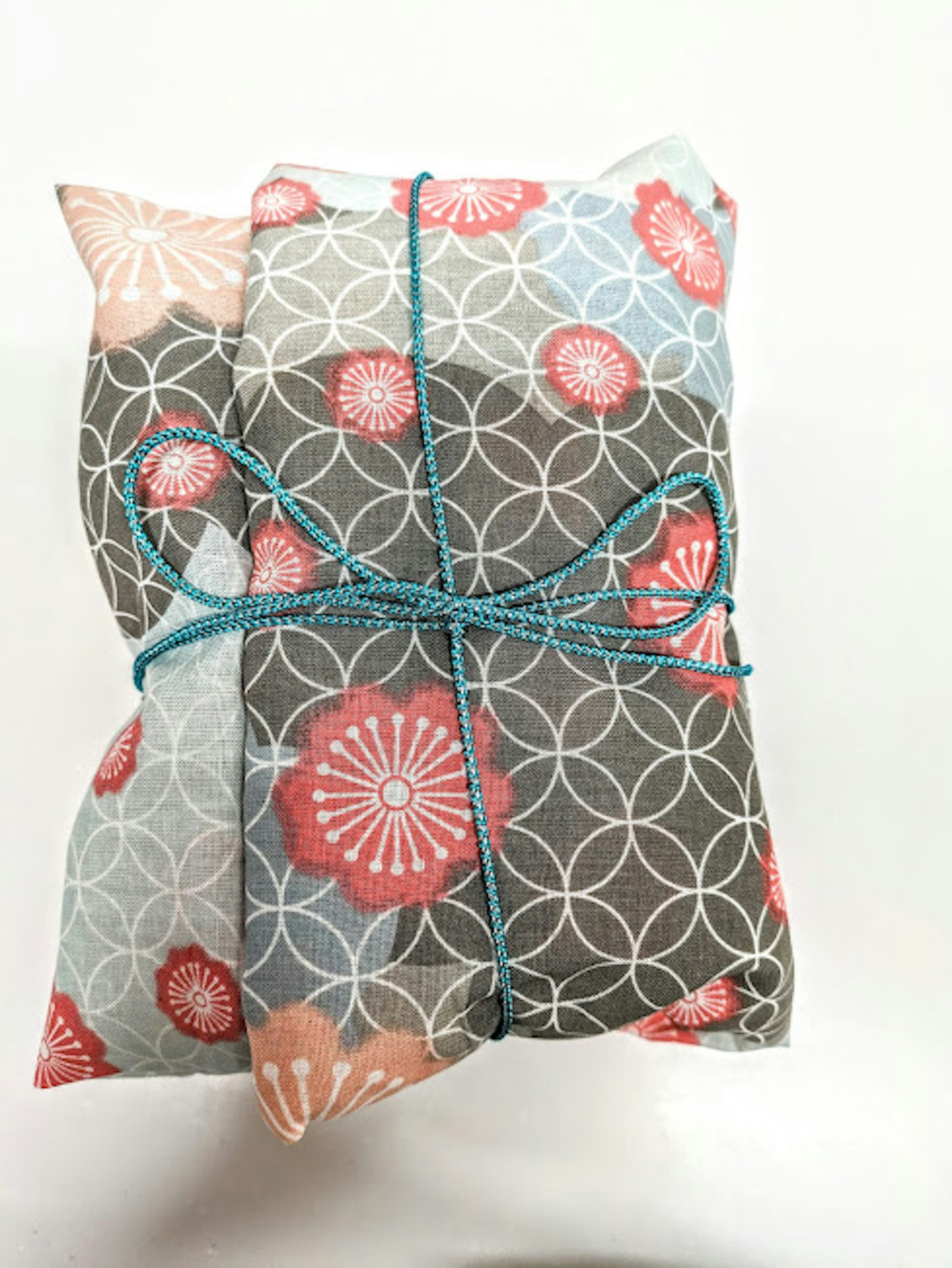 Gift wrapped in floral patterned paper tied with a blue string