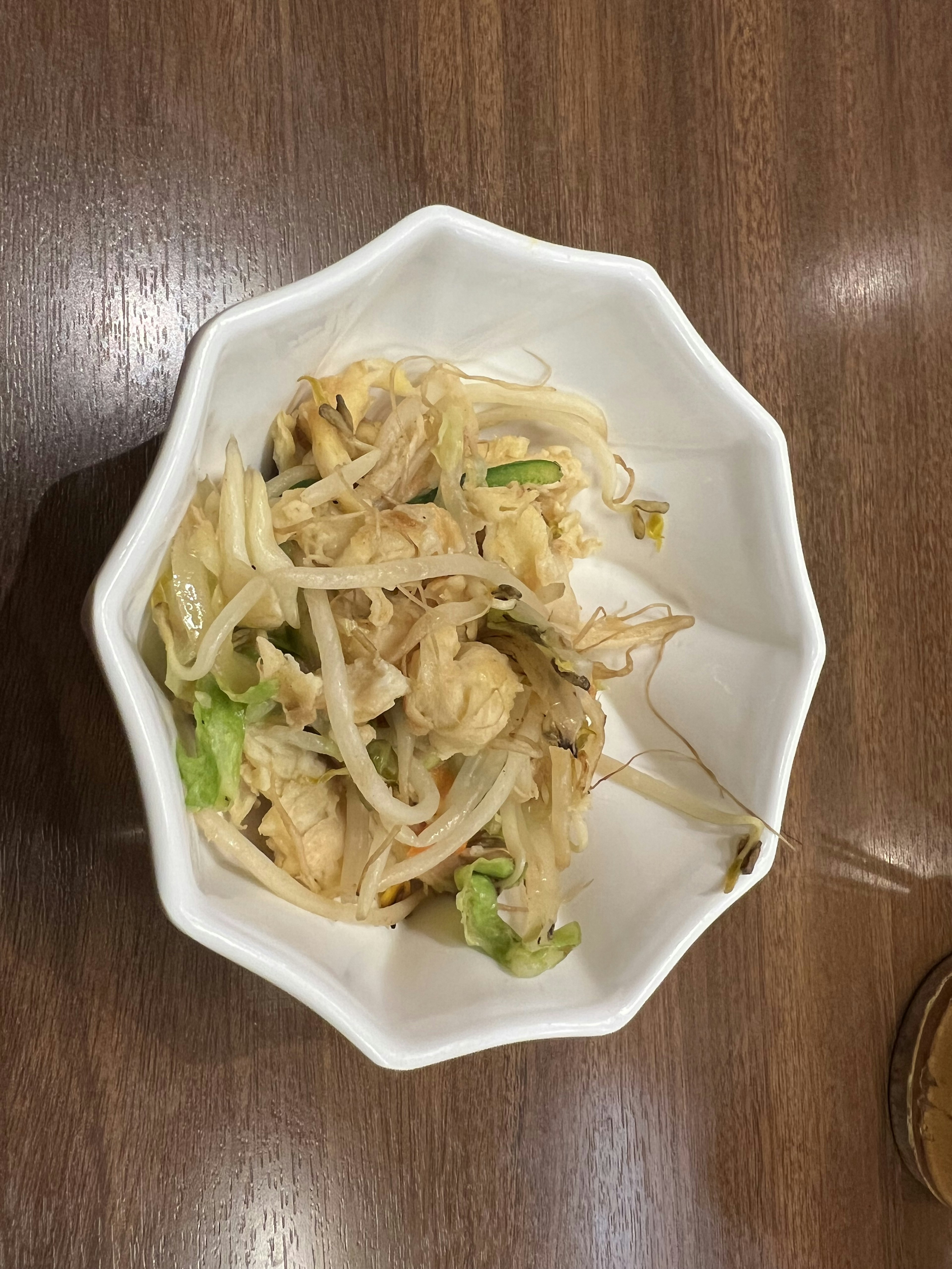 Dish of shredded chicken and vegetables served in a white octagonal bowl