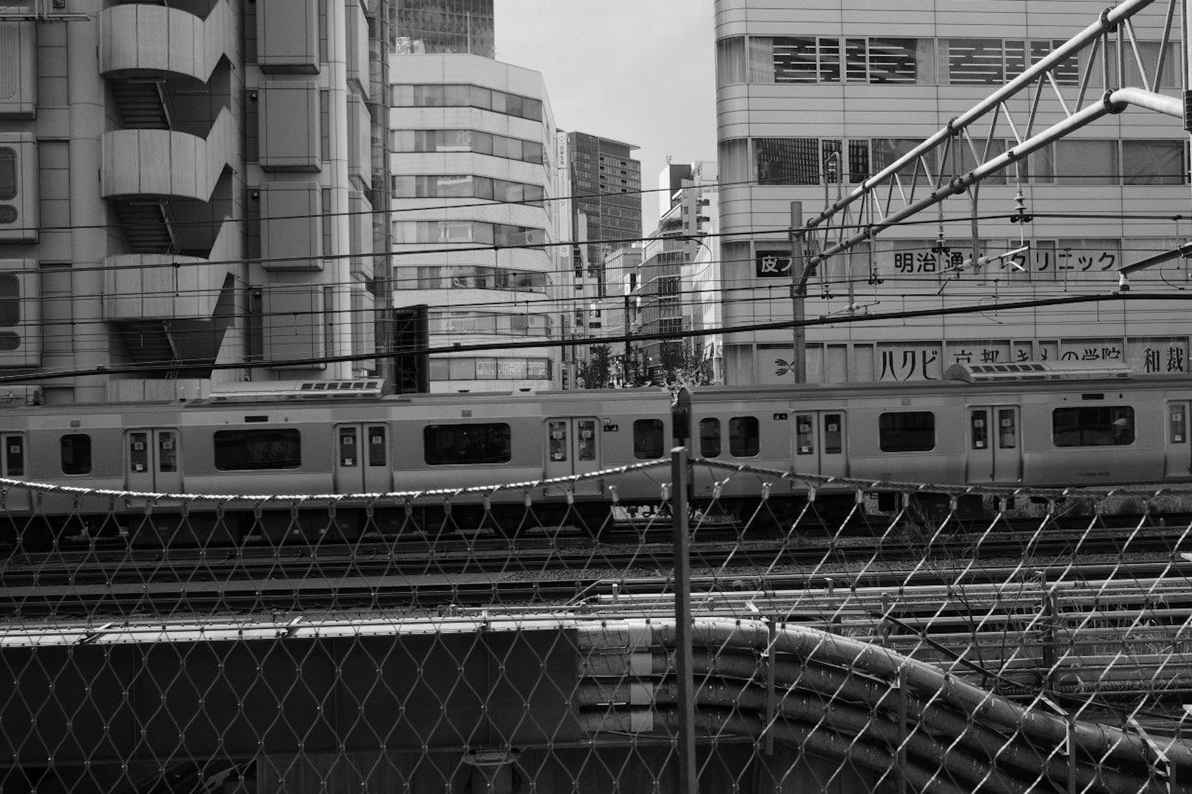 Paysage urbain en noir et blanc avec des voies de train et des bâtiments