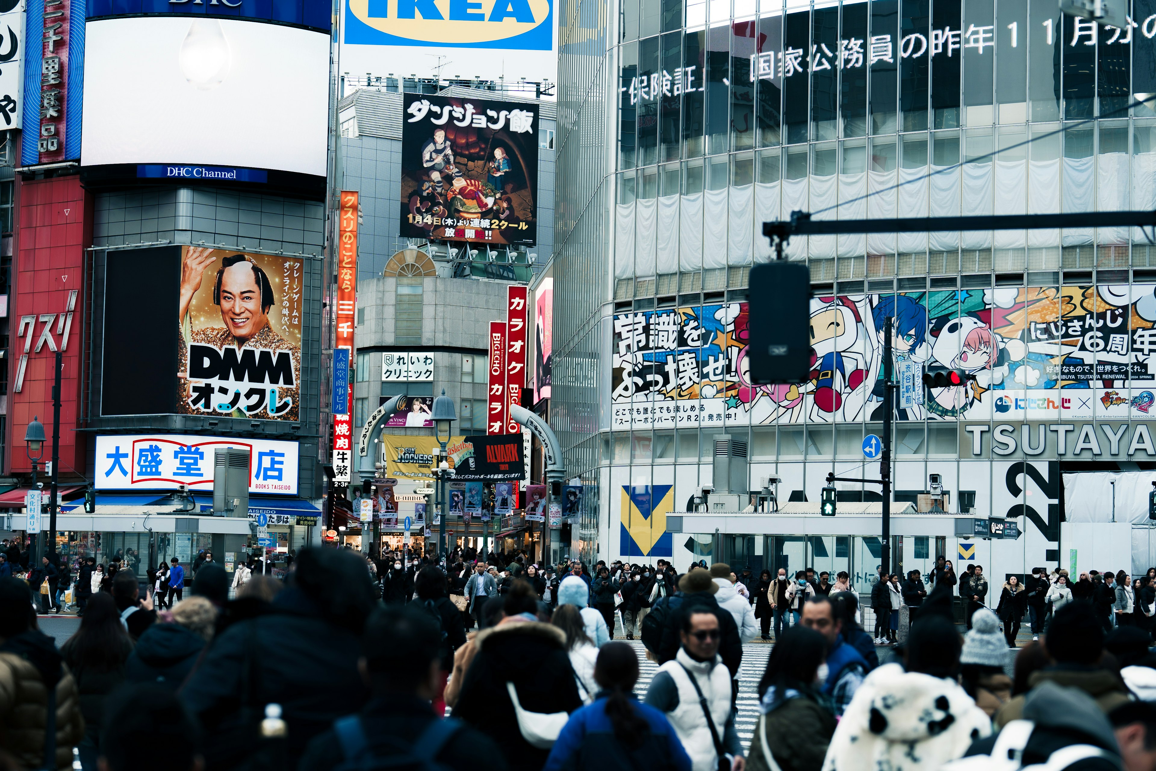 Busy Shibuya intersection filled with people featuring TSUTAYA signage and advertisements