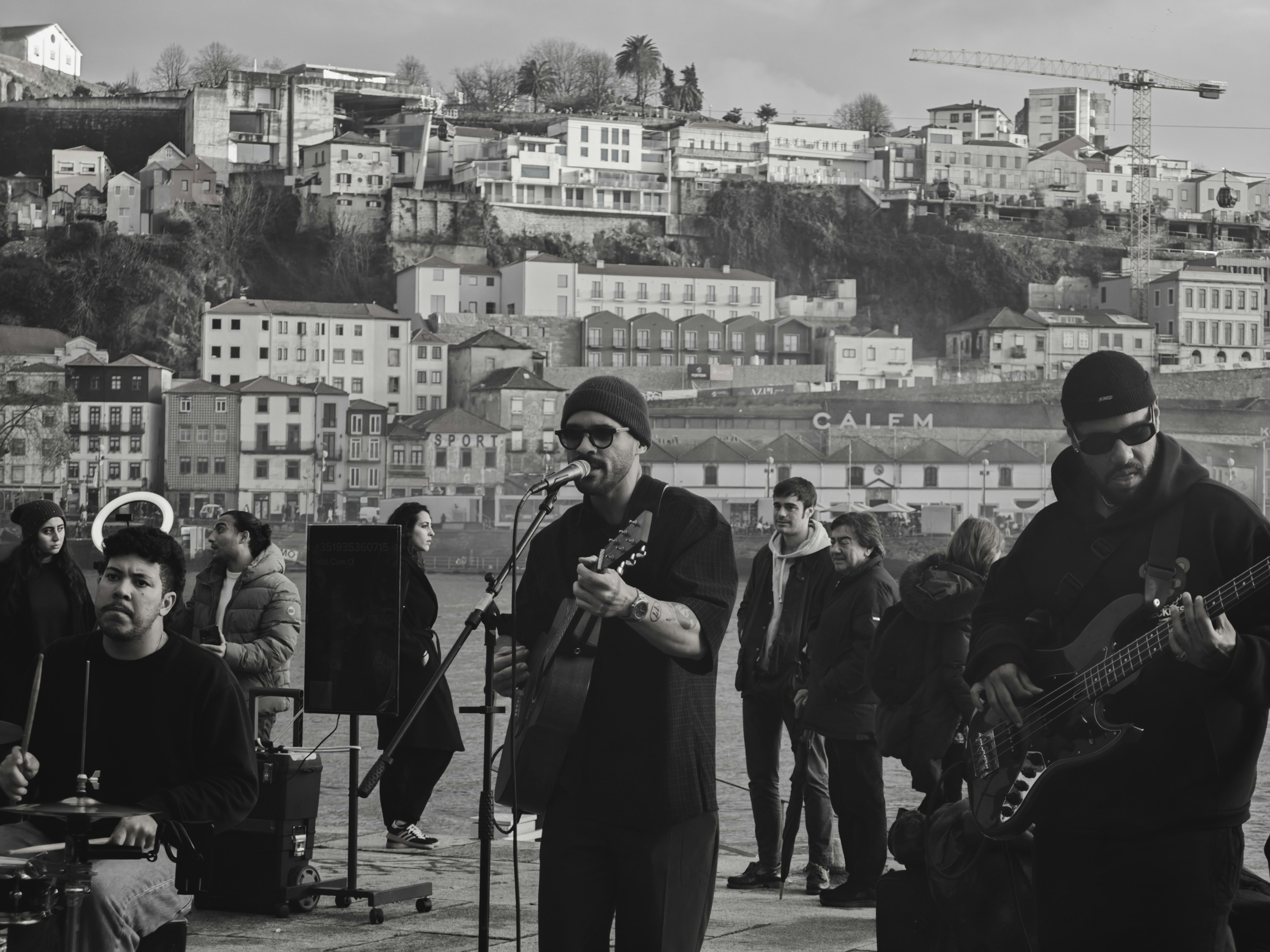 Black and white street performance featuring a band with urban landscape in the background