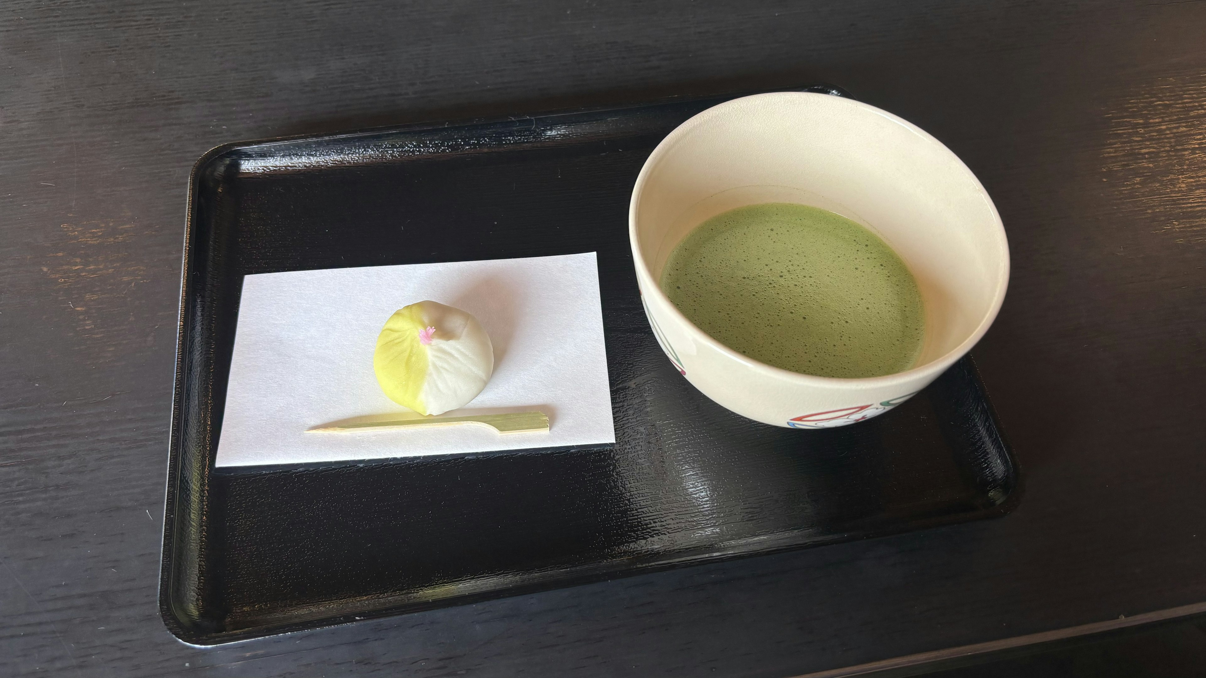 Black tray with green tea and traditional Japanese sweets