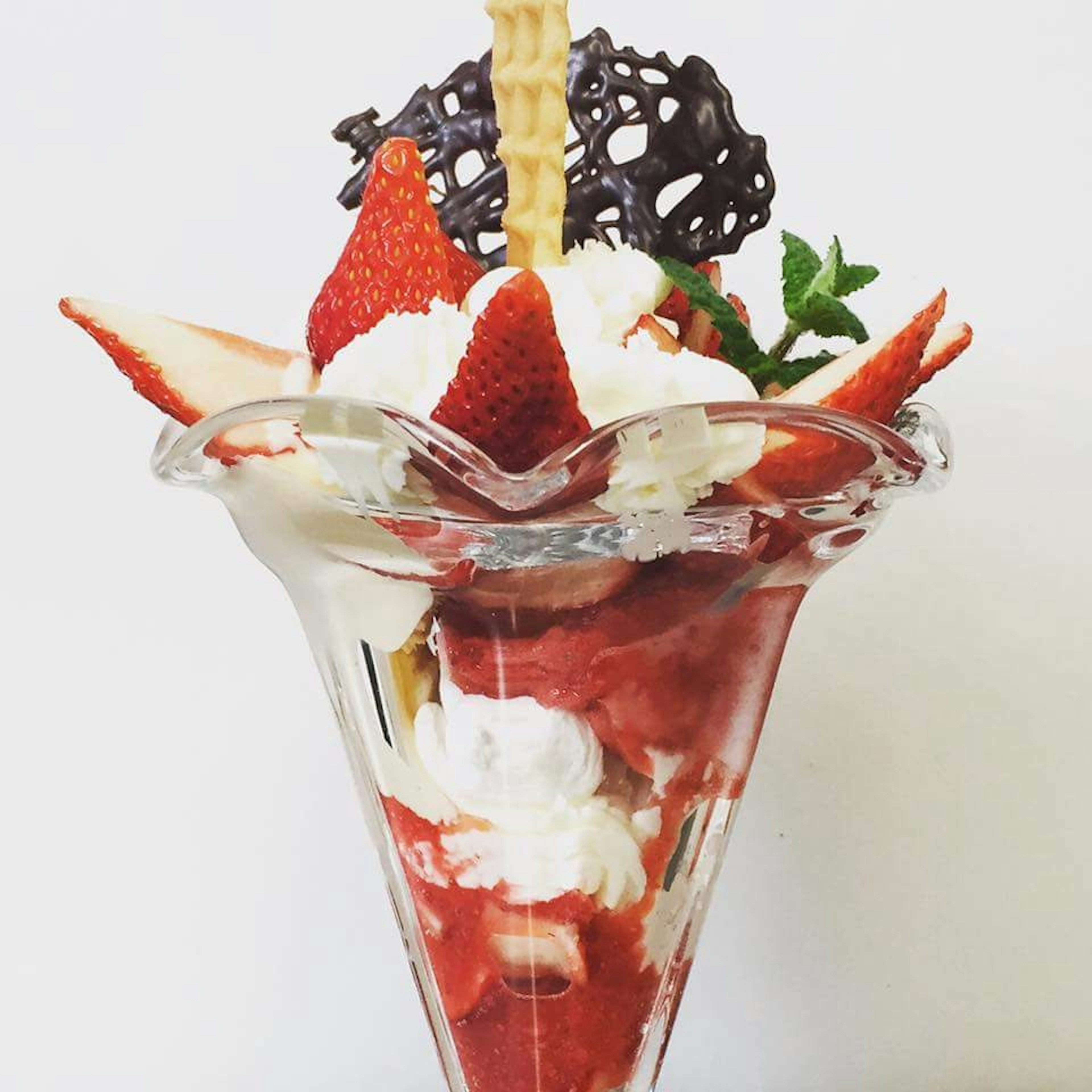 Postre de helado de fresa cubierto con crema batida y fresas frescas