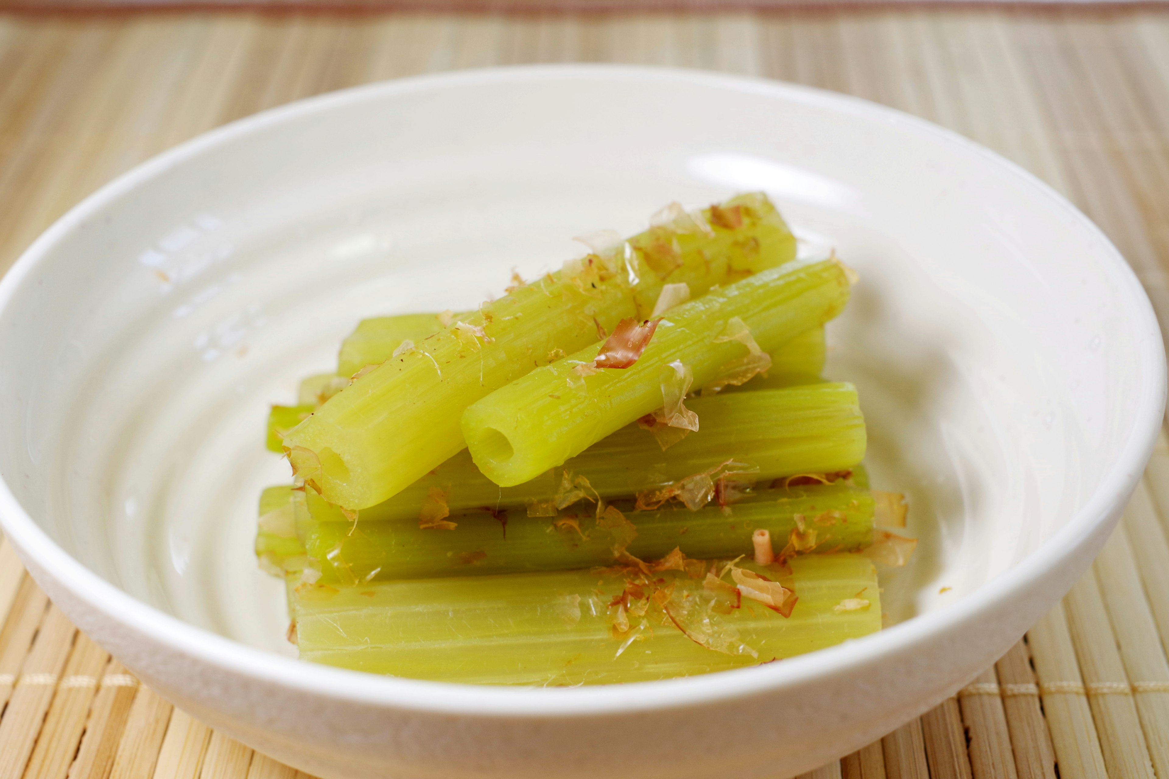 Celery sticks topped with fried onions in a white bowl