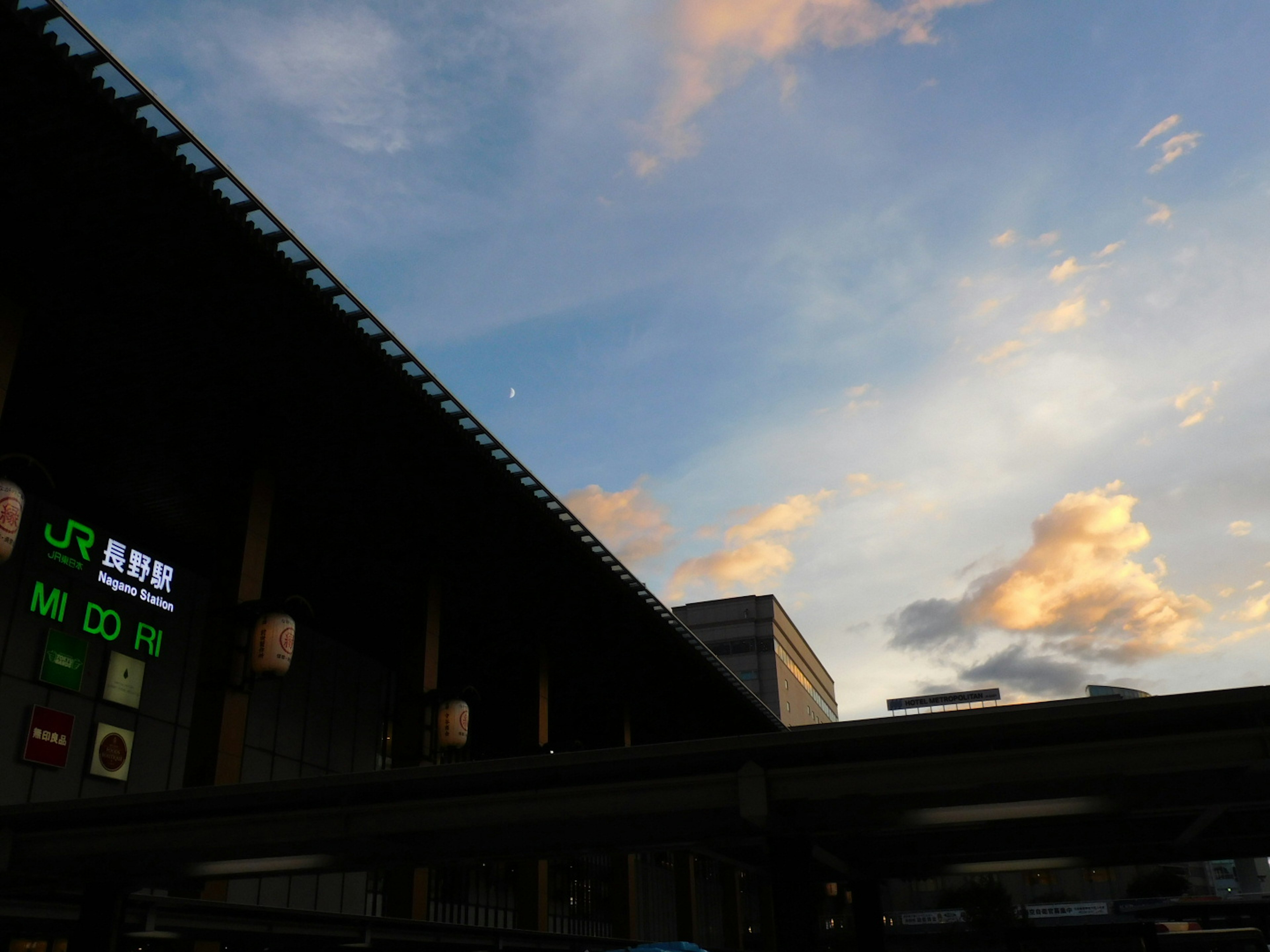 Silhouette of a train station against a sunset sky