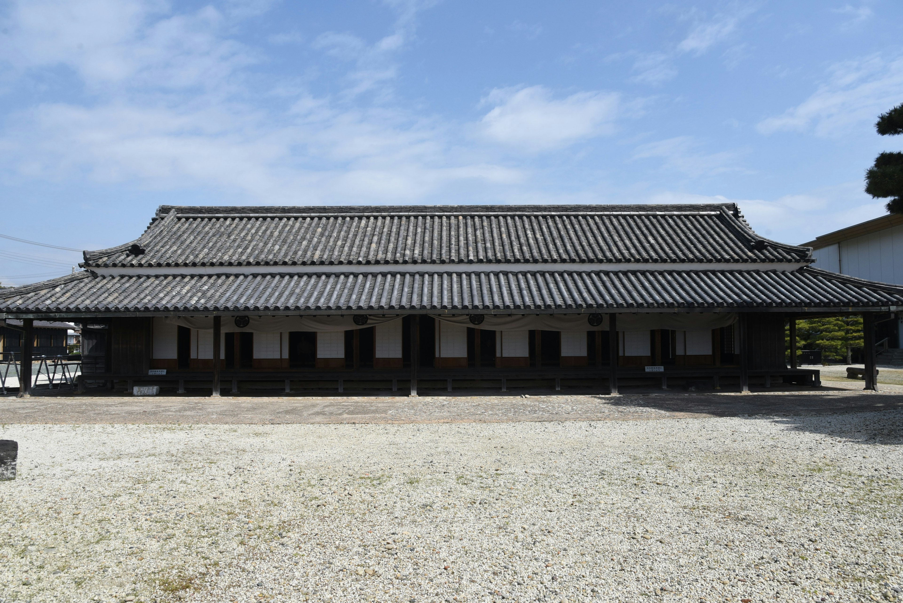 Struktur arsitektur Jepang tradisional dengan atap genteng dan lingkungan yang tenang