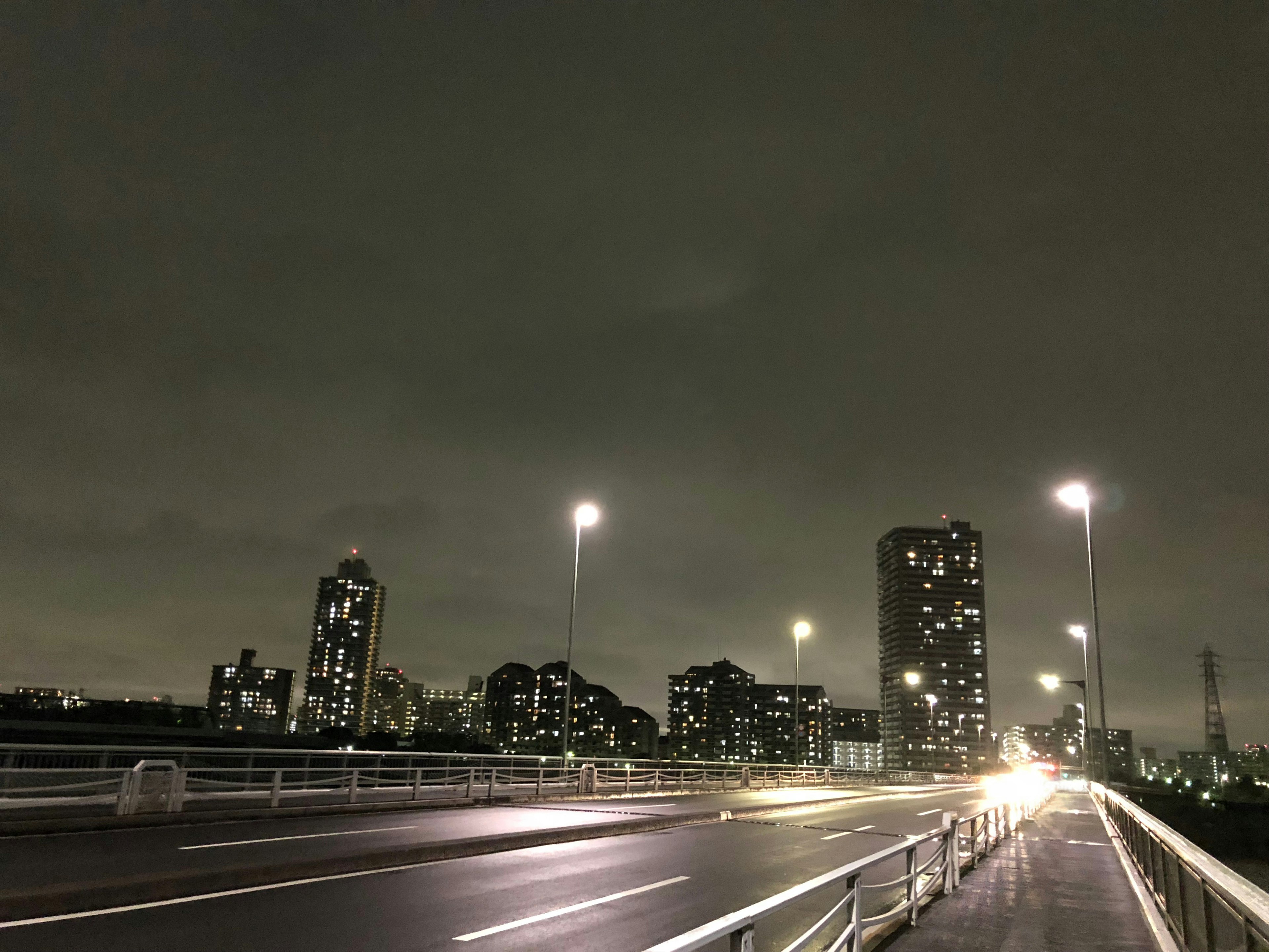 Pemandangan kota malam dengan gedung pencakar langit yang diterangi dan jalan