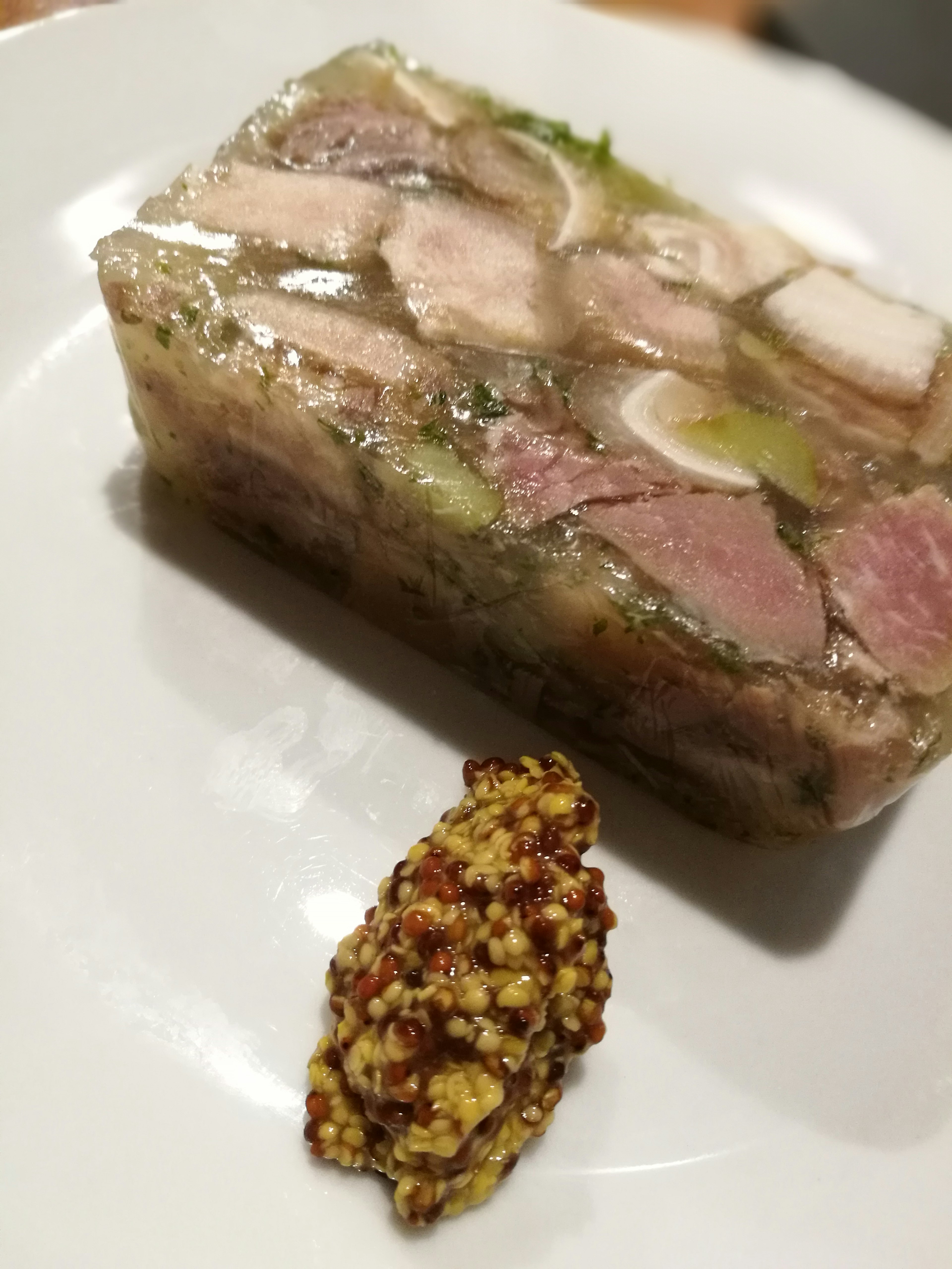 Terrine served on a plate with a dollop of mustard