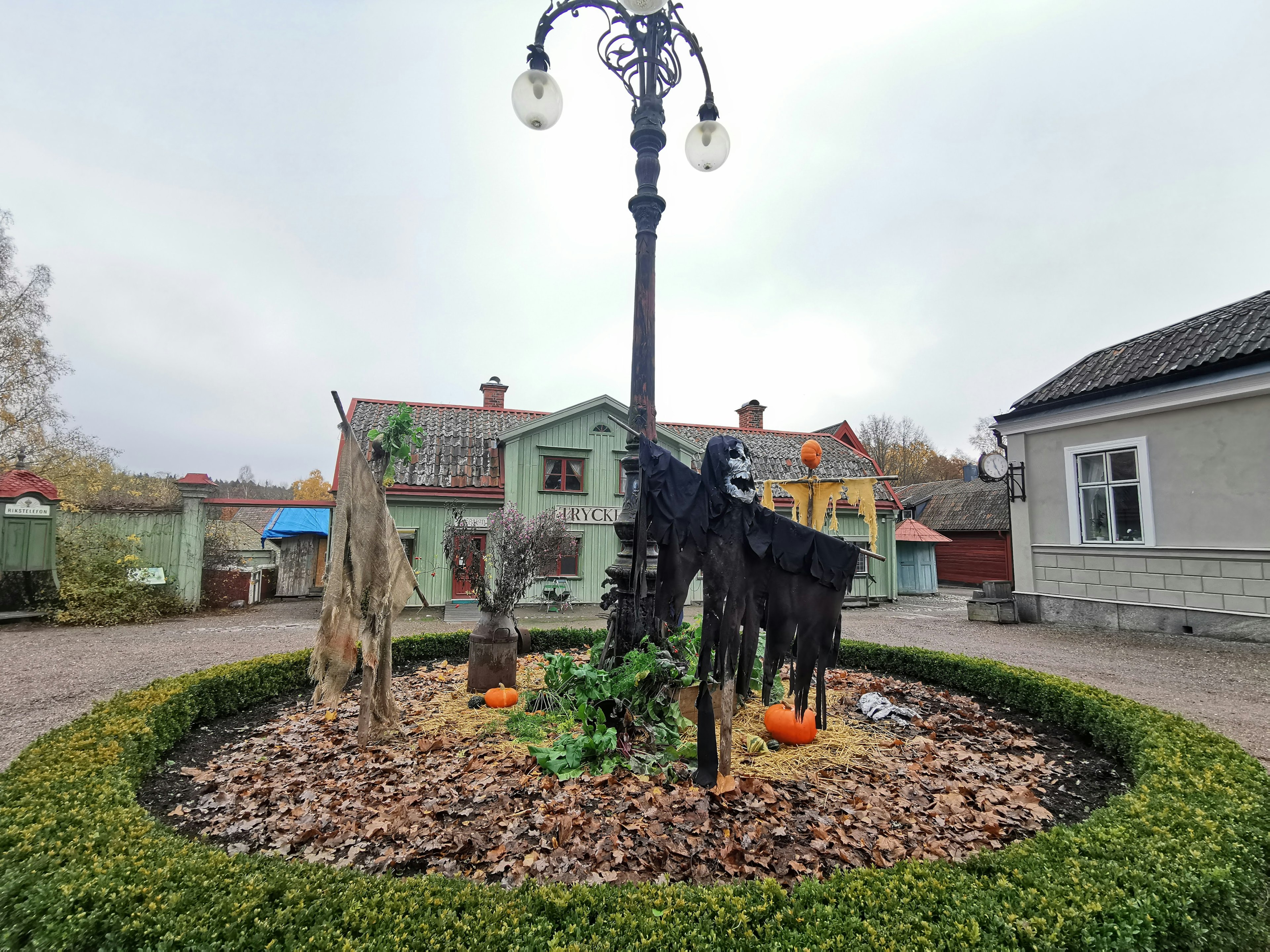 公園の中央にある黒い馬の装飾とランプポール周囲の小道と家々