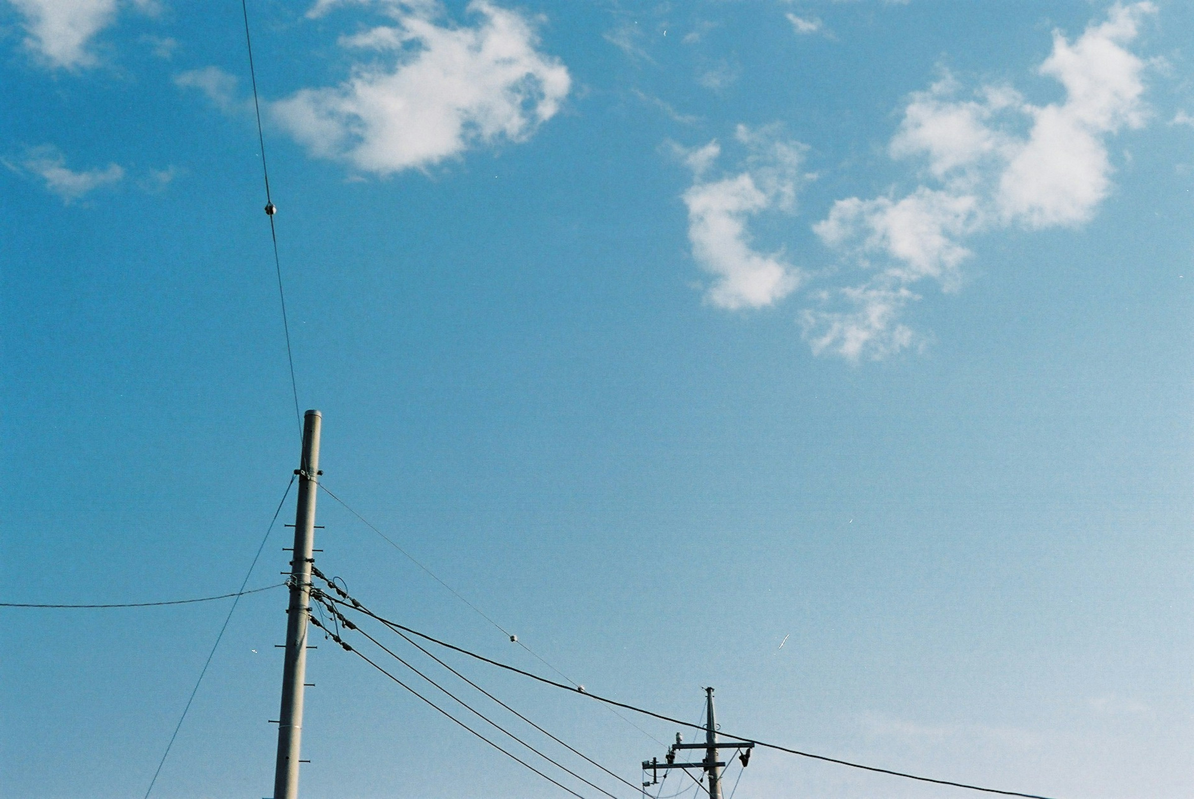 Poteaux électriques et fils contre un ciel bleu clair