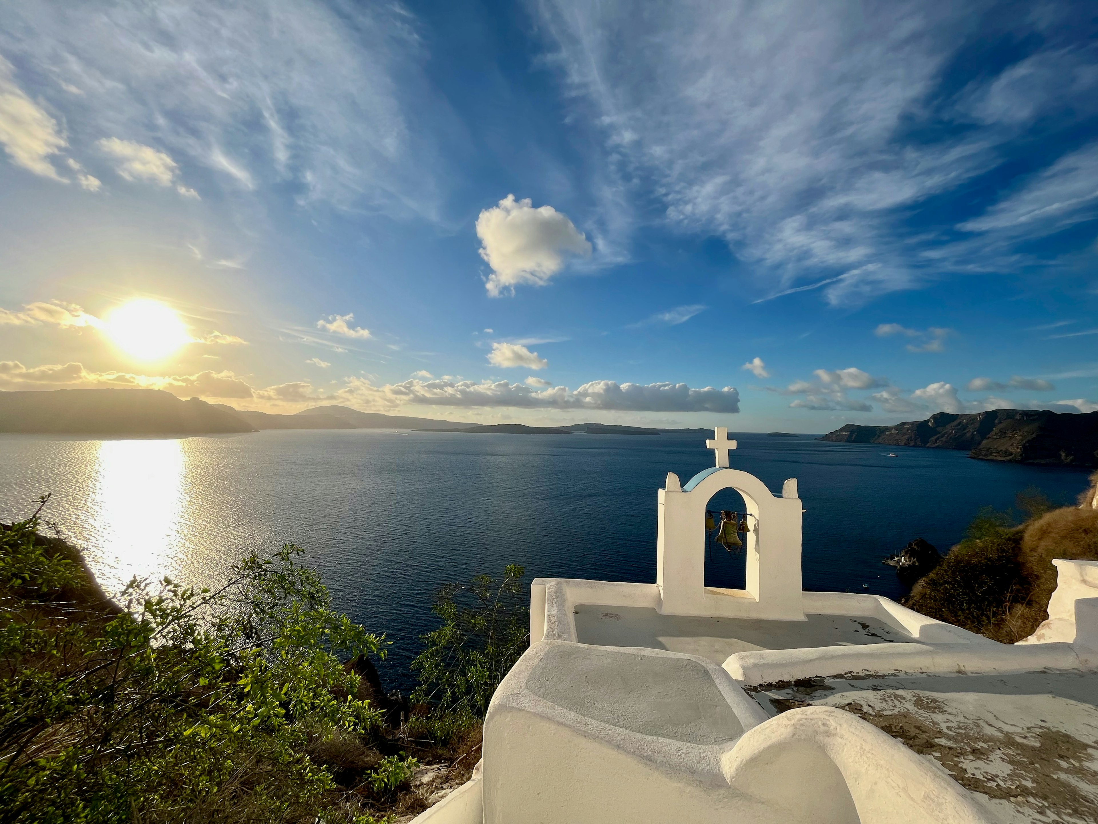 Scenic view of the sea with a silhouette of a white church against a sunset