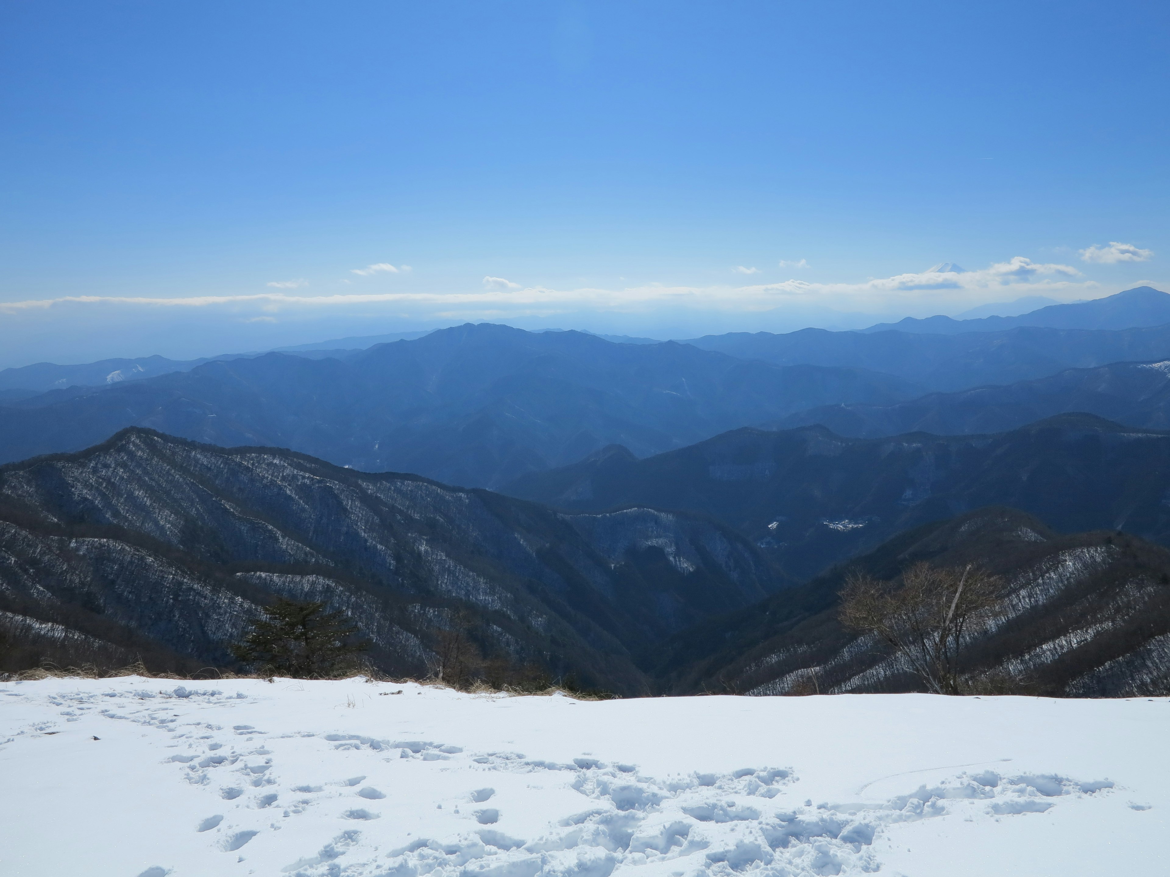 Snow-covered mountain landscape with expansive blue sky