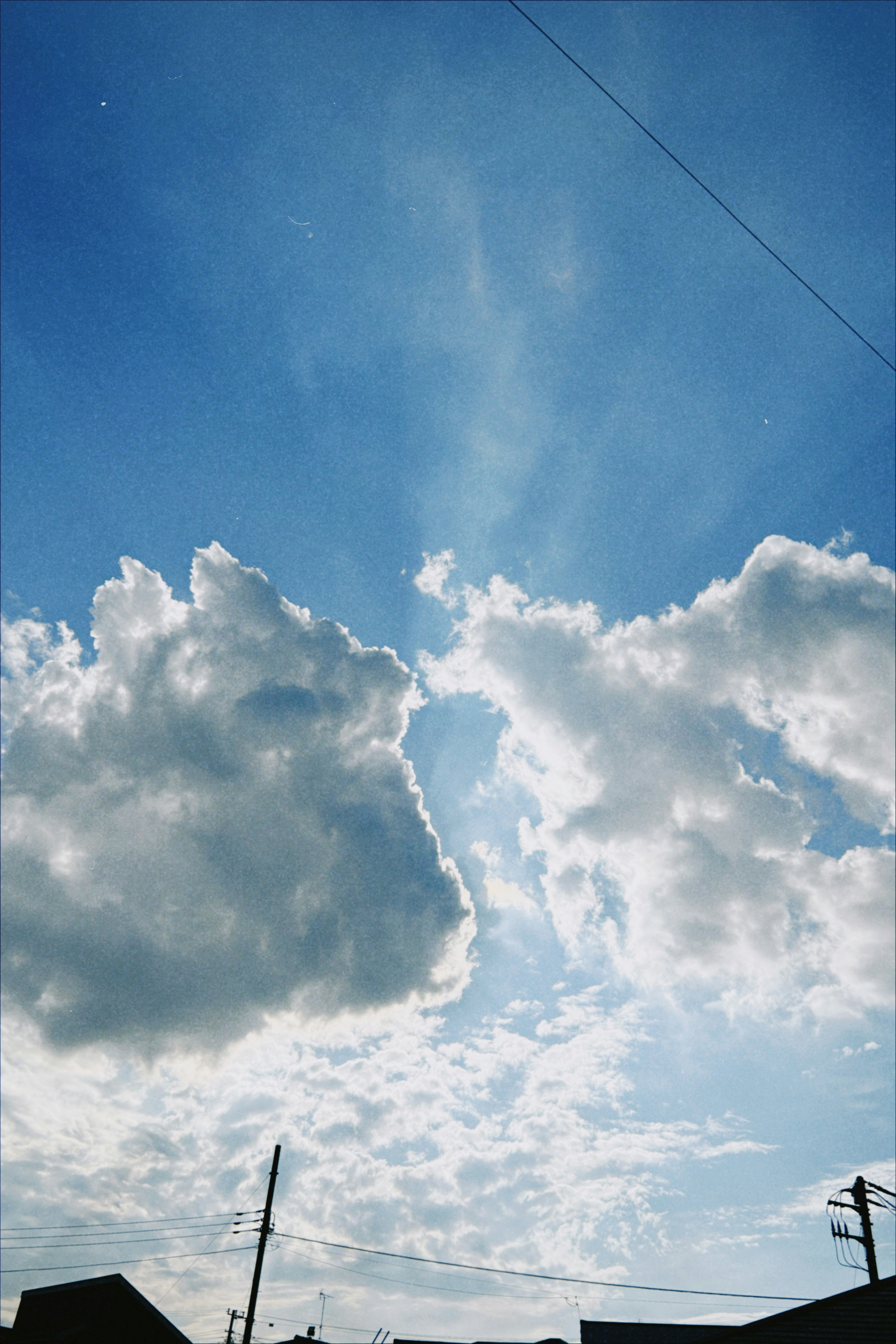 Nubes esponjosas en un cielo azul brillante con rayos de sol