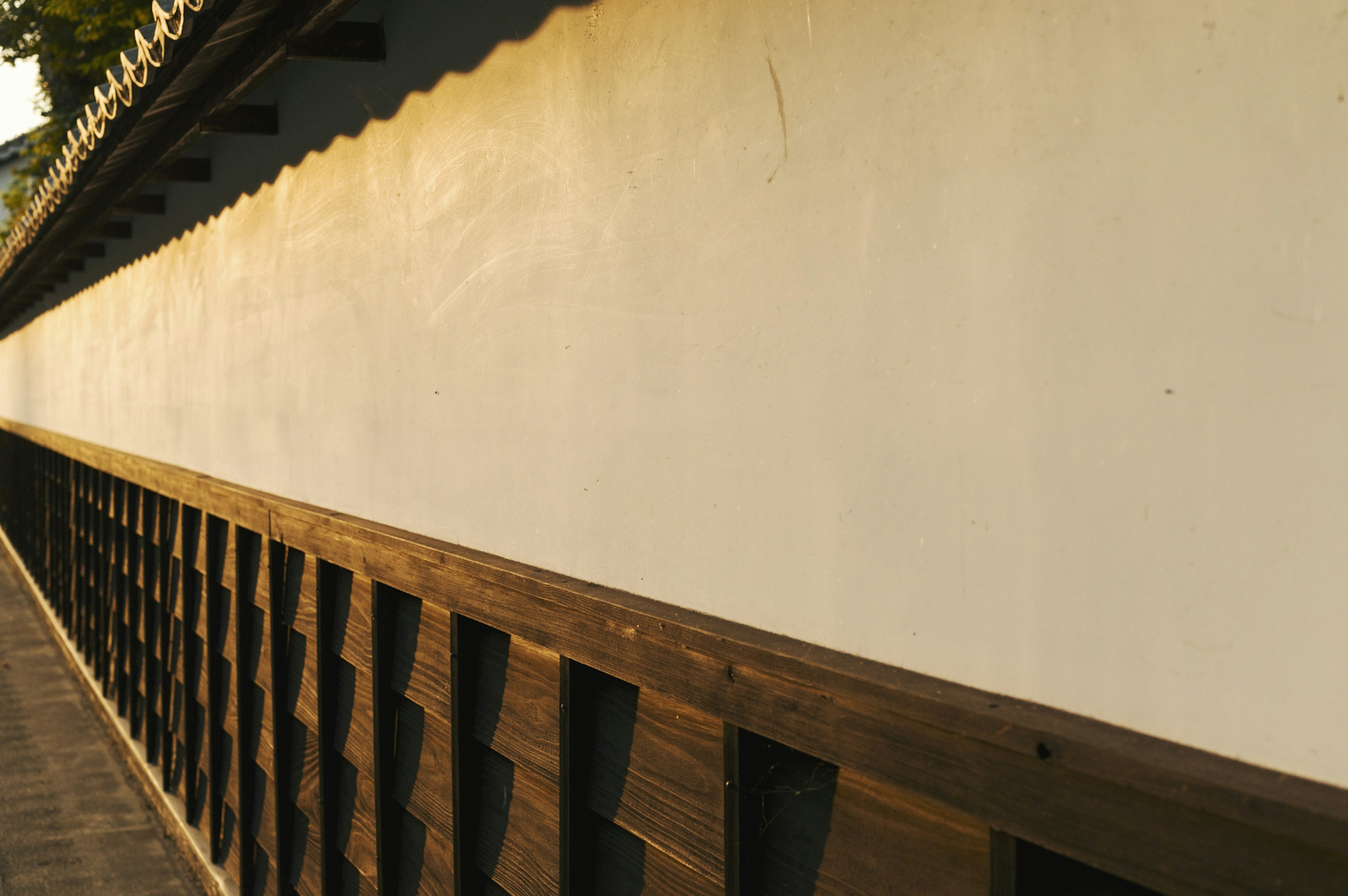 Una vista serena con un muro bianco e una recinzione in legno