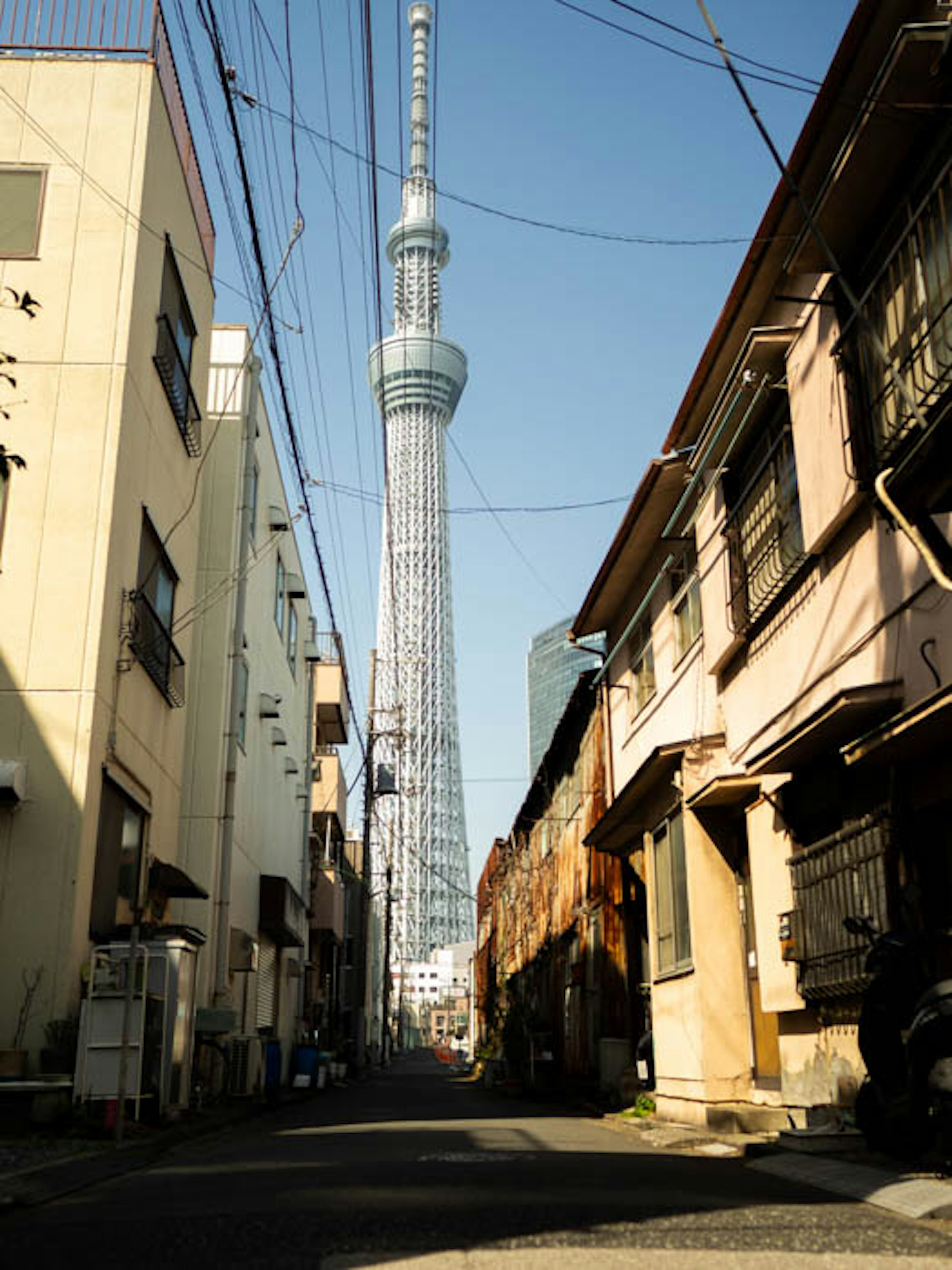 Narrow alleyway featuring Tokyo Skytree in the background