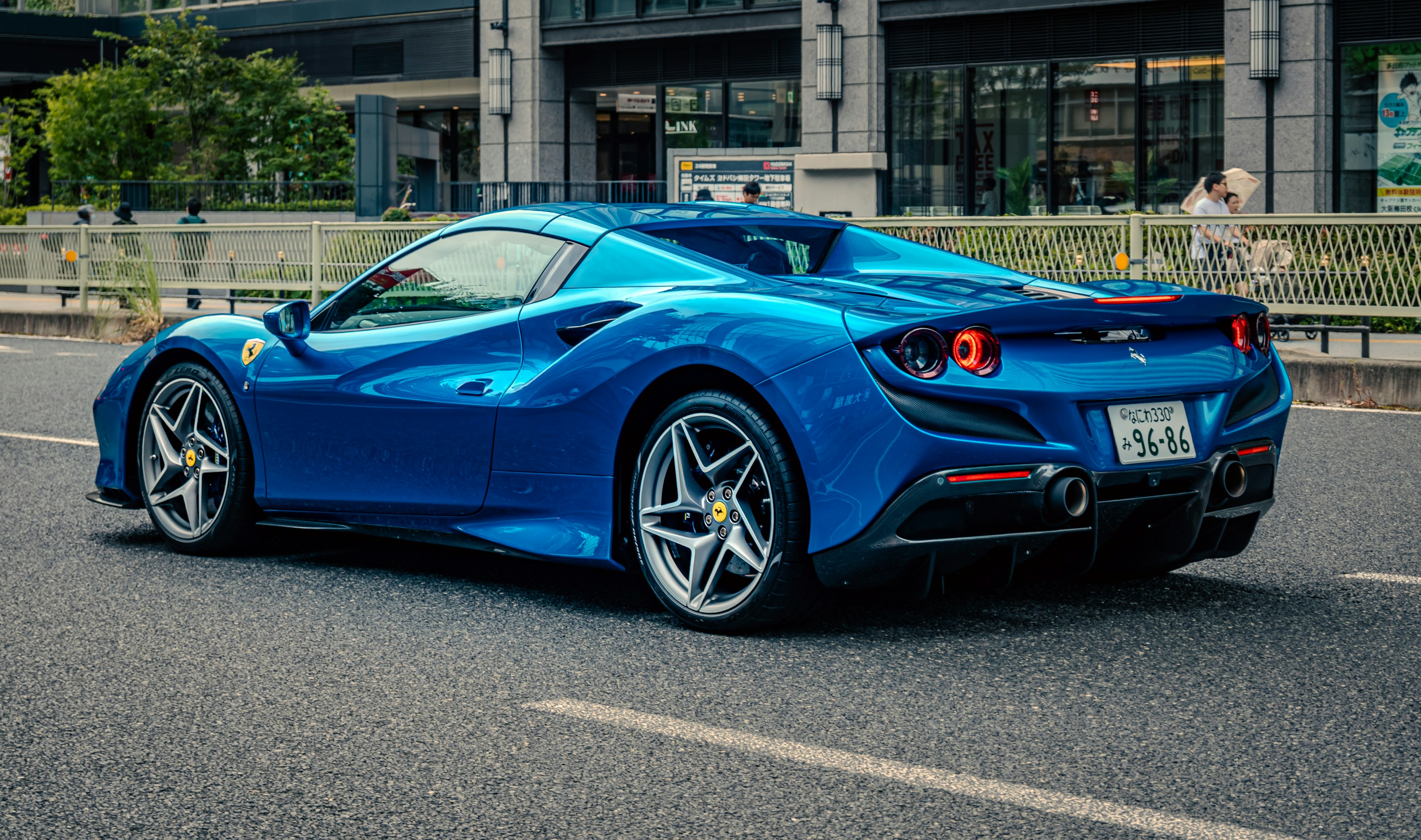 Ferrari 488 biru dilihat dari belakang di jalan kota