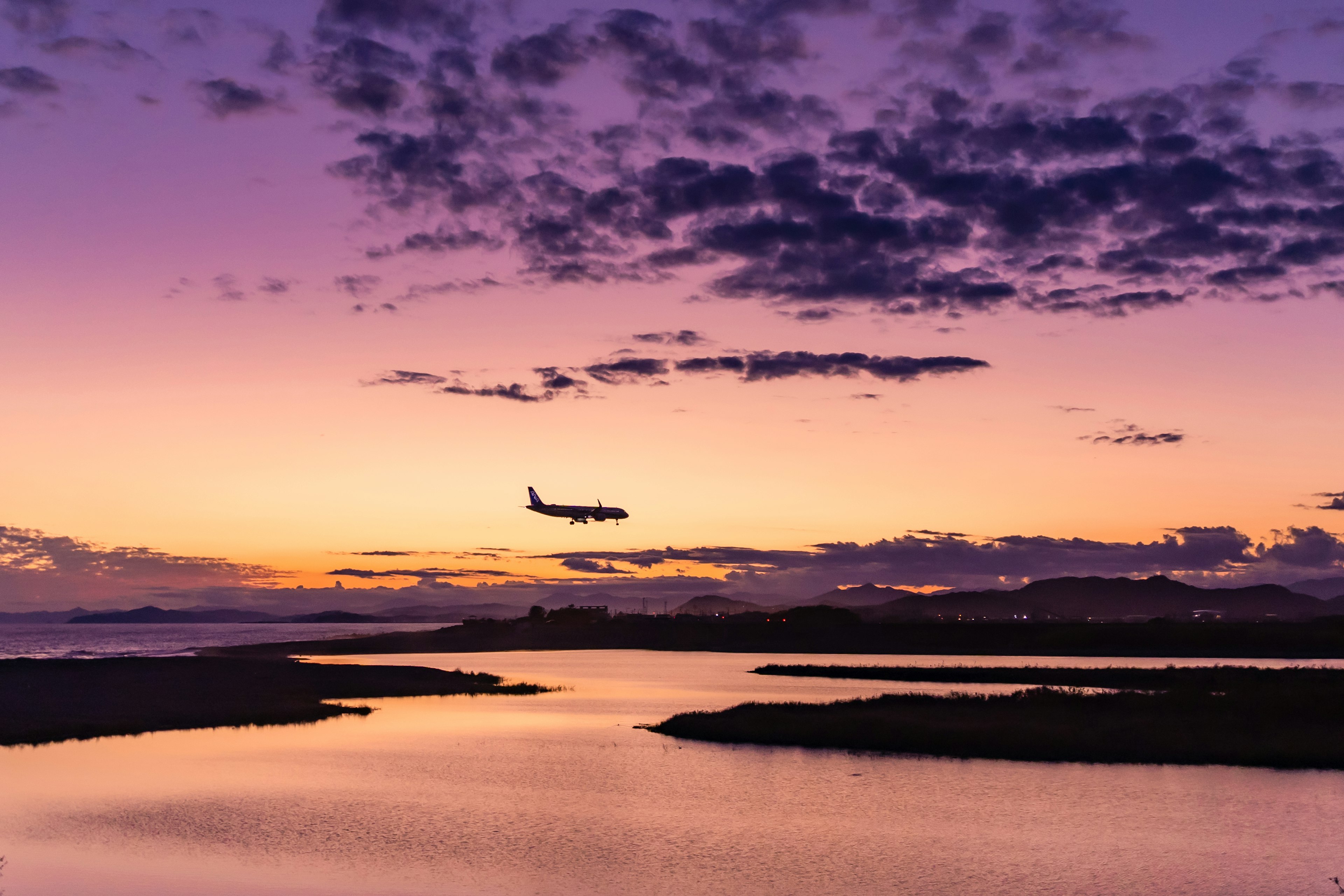 美しい夕焼けの空を背景に飛行機が着陸する風景