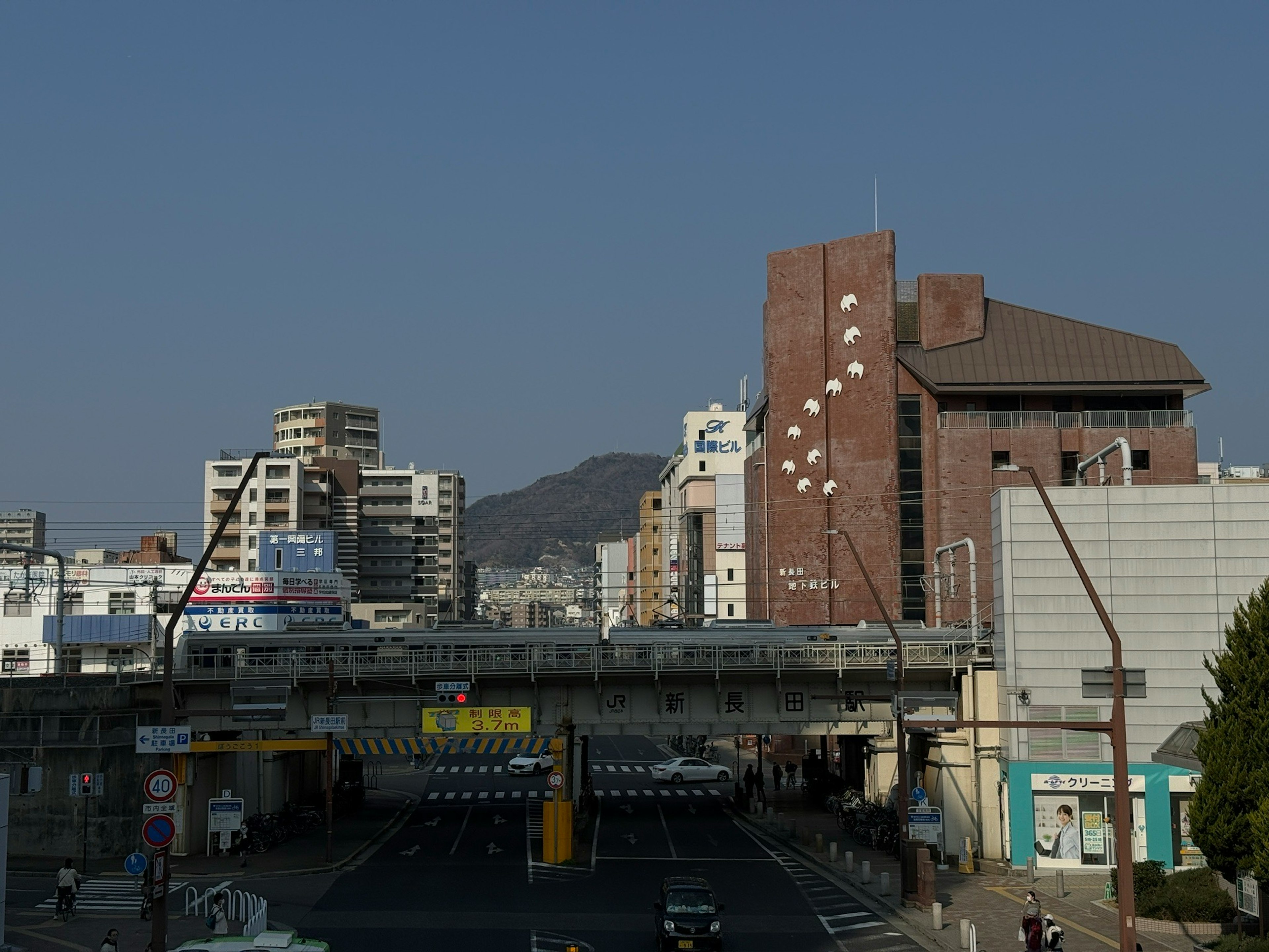 Paesaggio urbano sotto un cielo blu con un ponte ferroviario e edifici