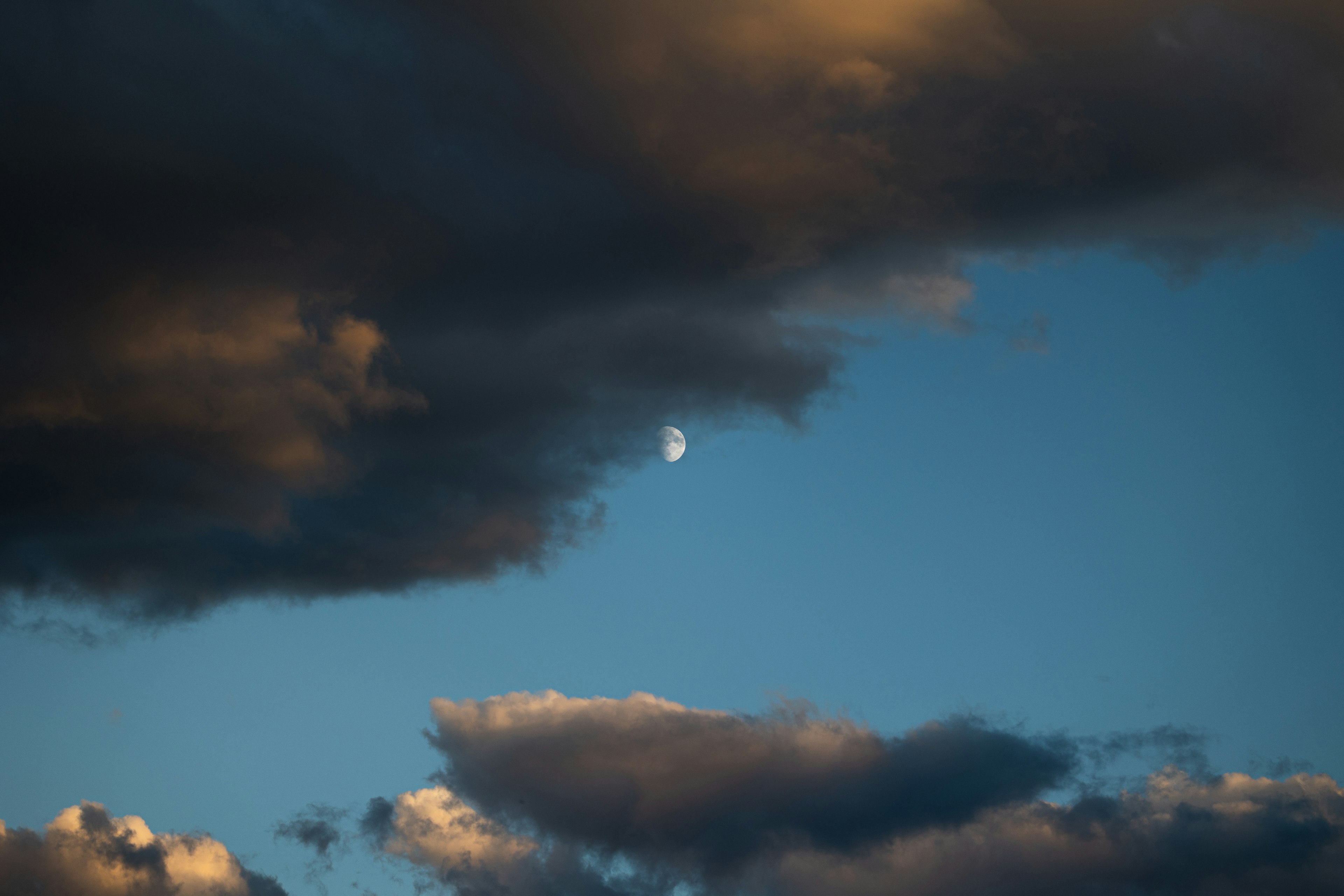 青空と雲に囲まれた月の写真