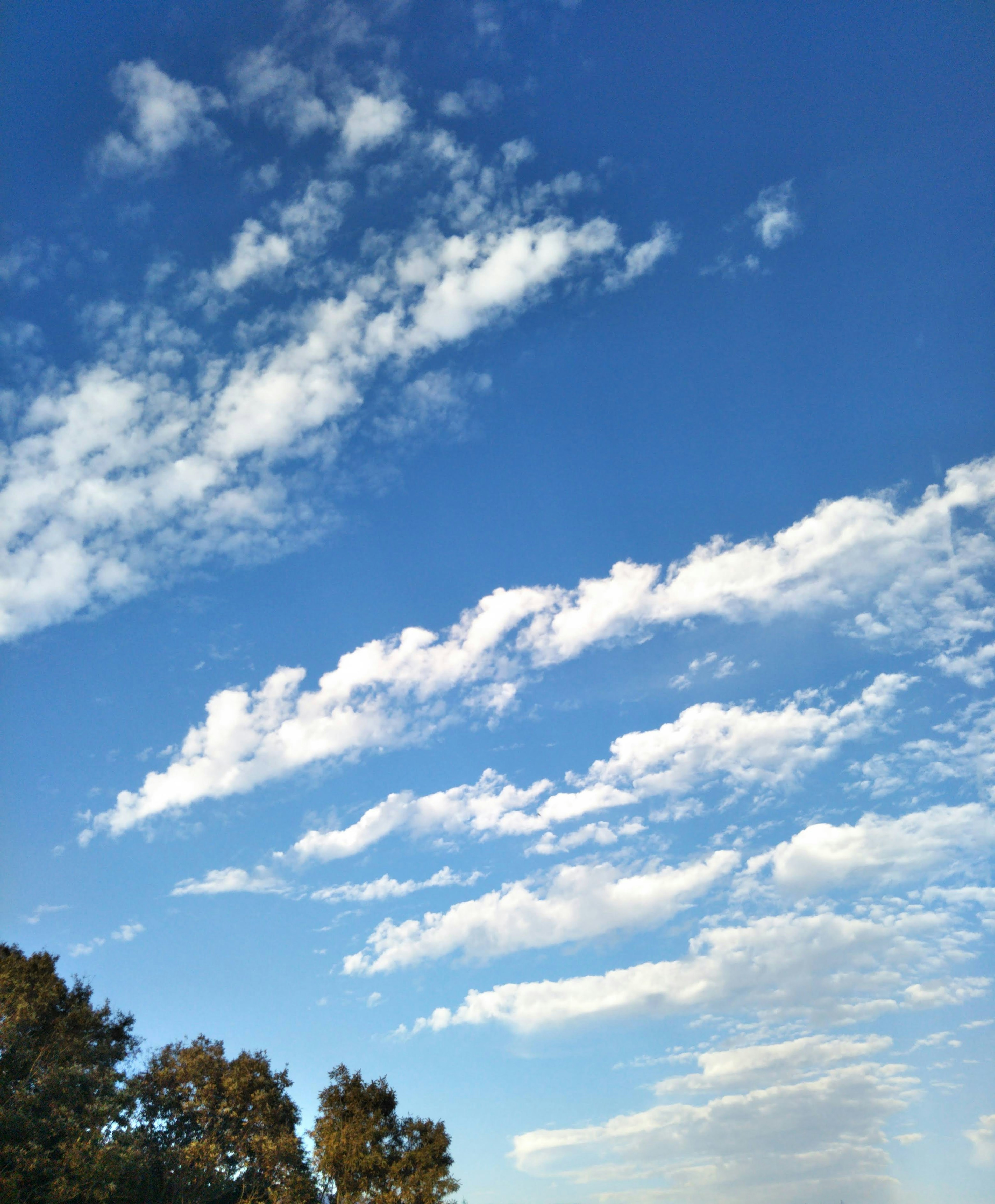 Un cielo azul claro con nubes blancas en patrón de rayas