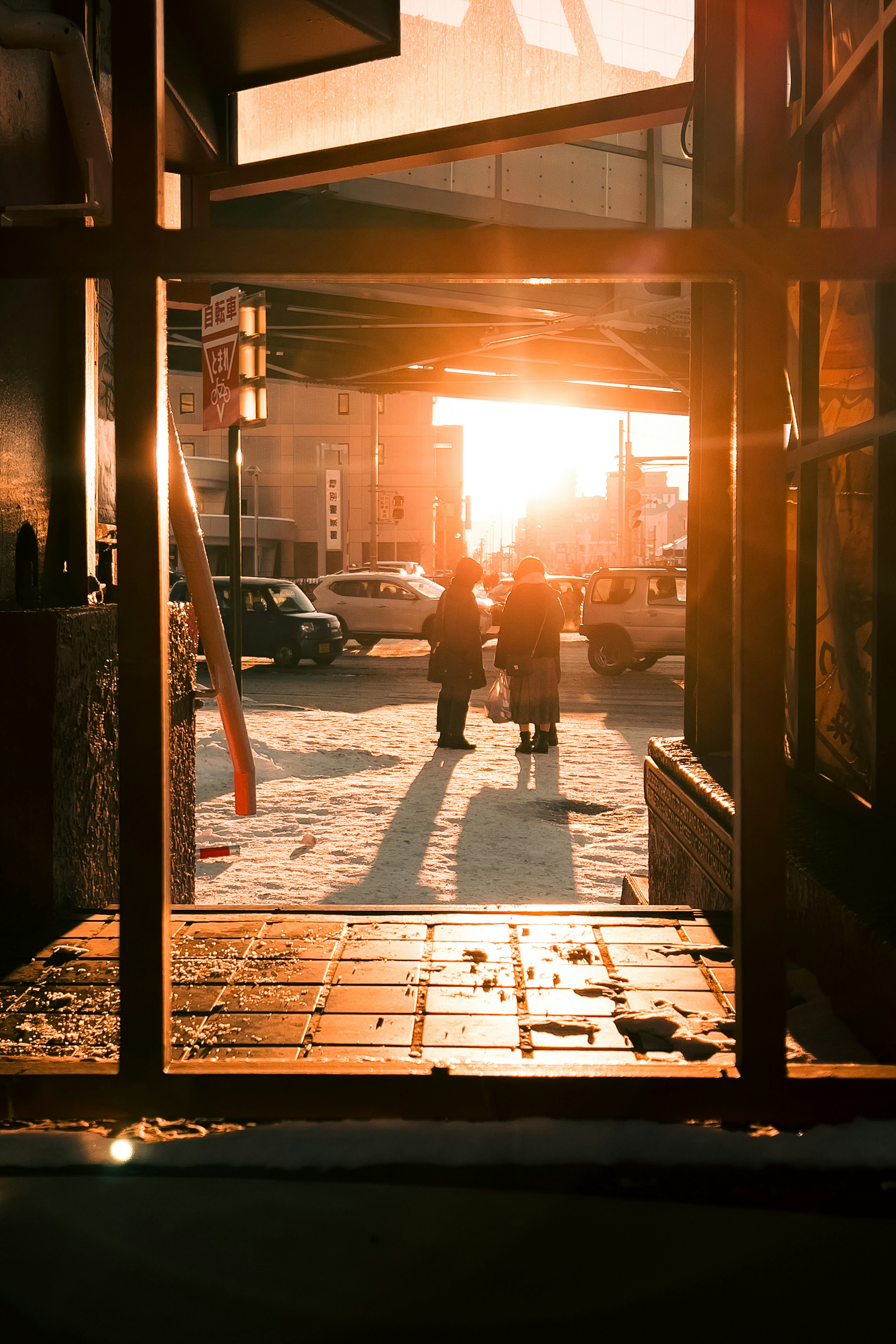 Silhouetten von Menschen, die mit Sonnenuntergang im Hintergrund in einer städtischen Umgebung gehen