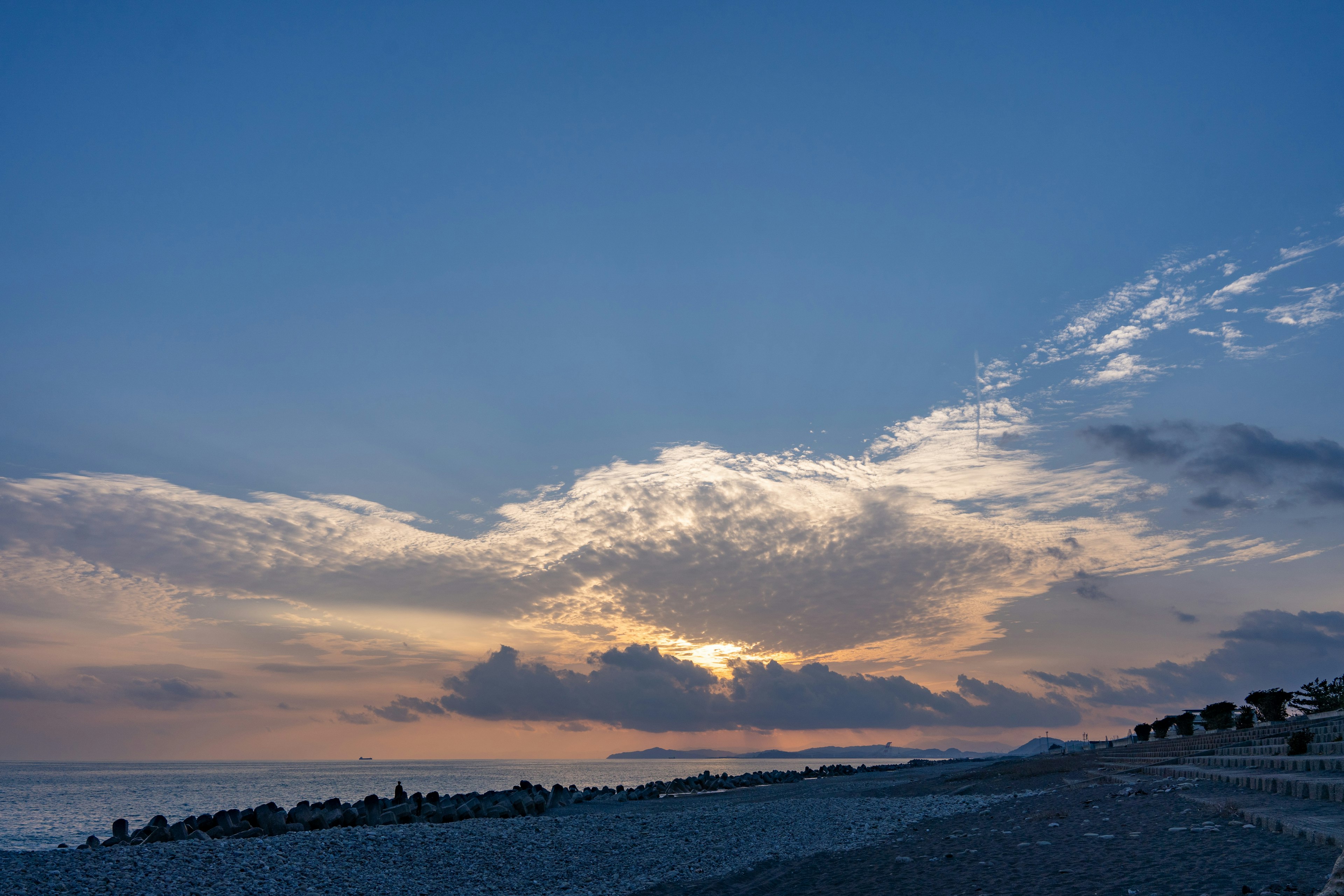 夕焼けのビーチの風景、雲と海の美しいコントラスト