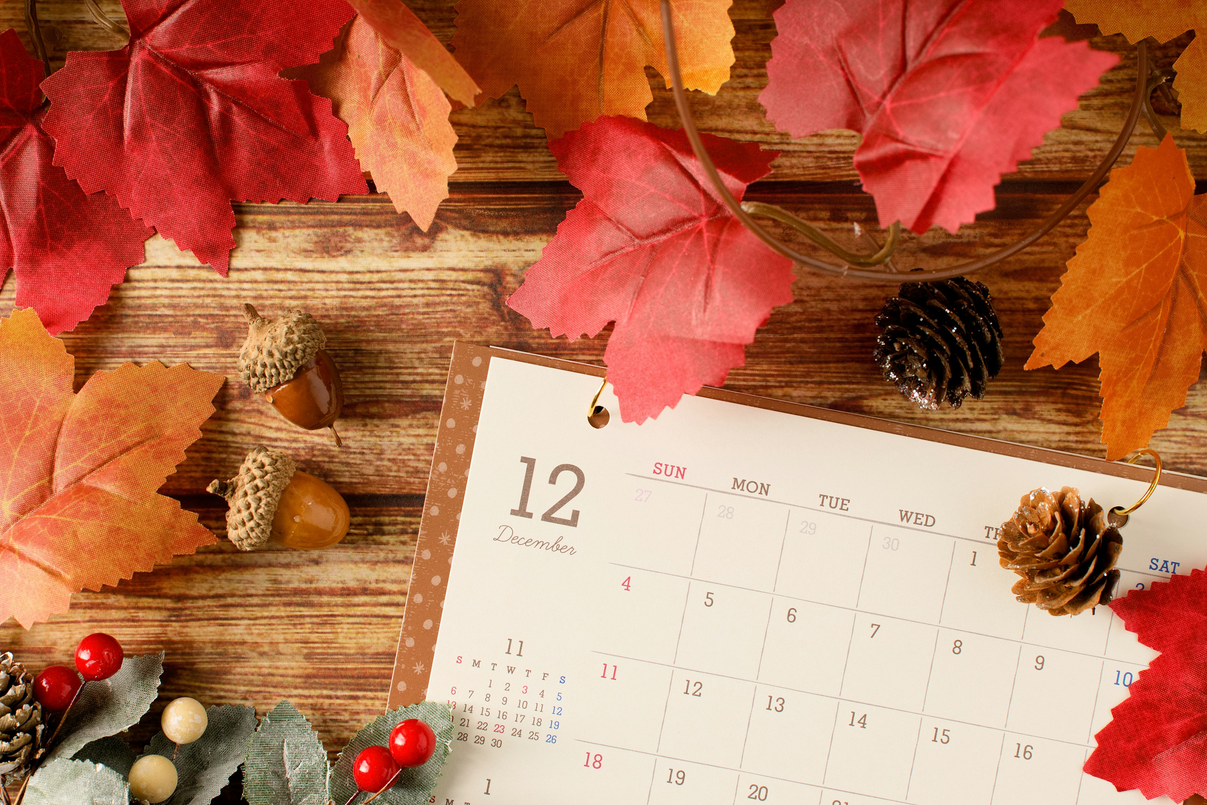 Hojas de otoño y calendario sobre fondo de madera