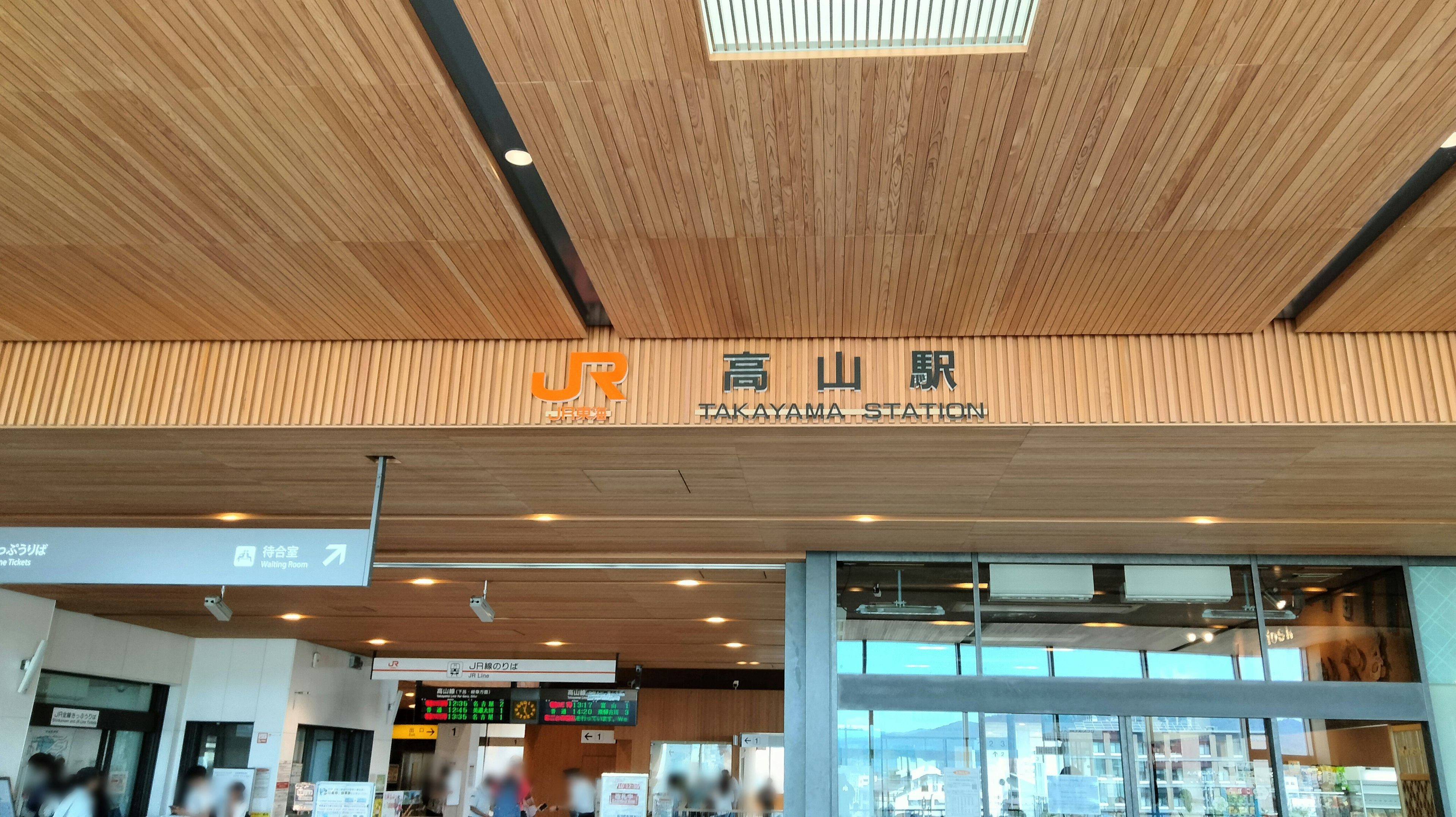 Intérieur de la gare de Takayama avec décor en bois et éclairage lumineux