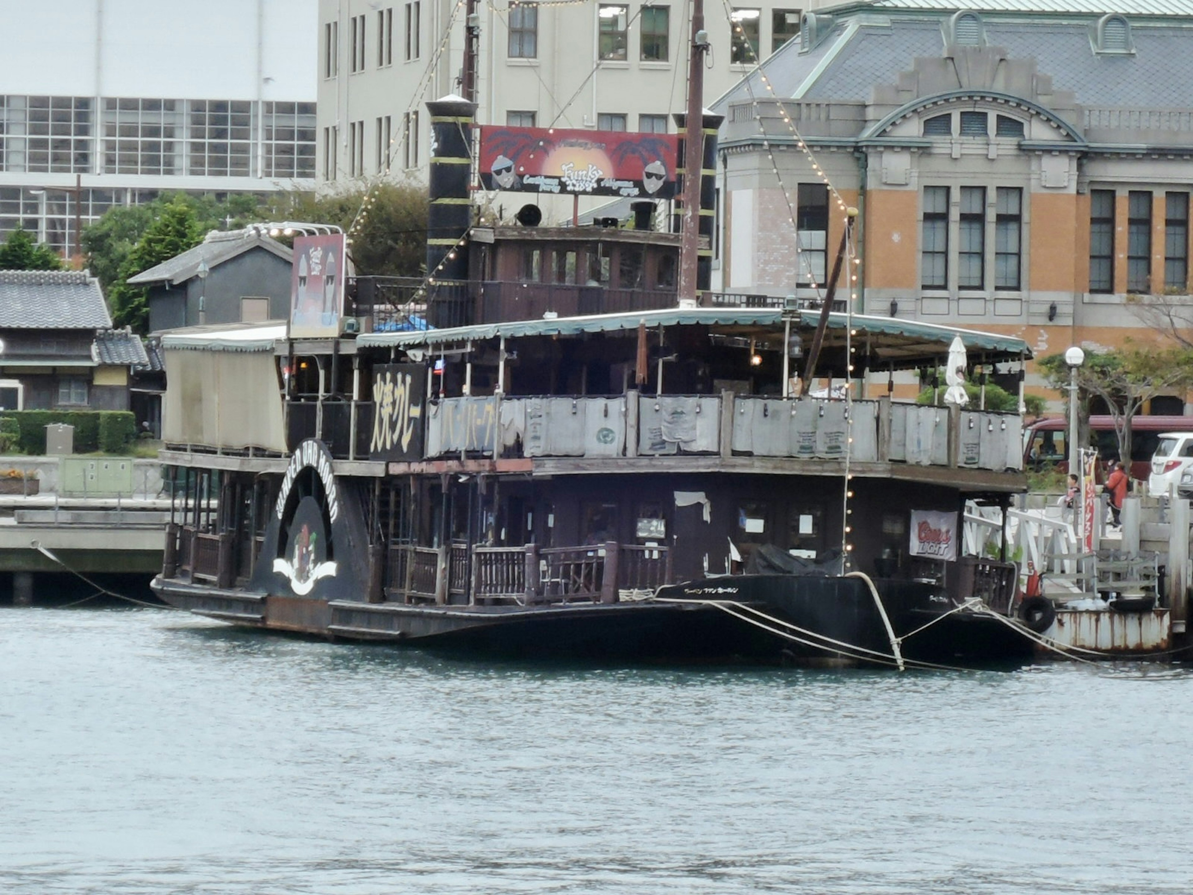 A black steamship docked at the harbor