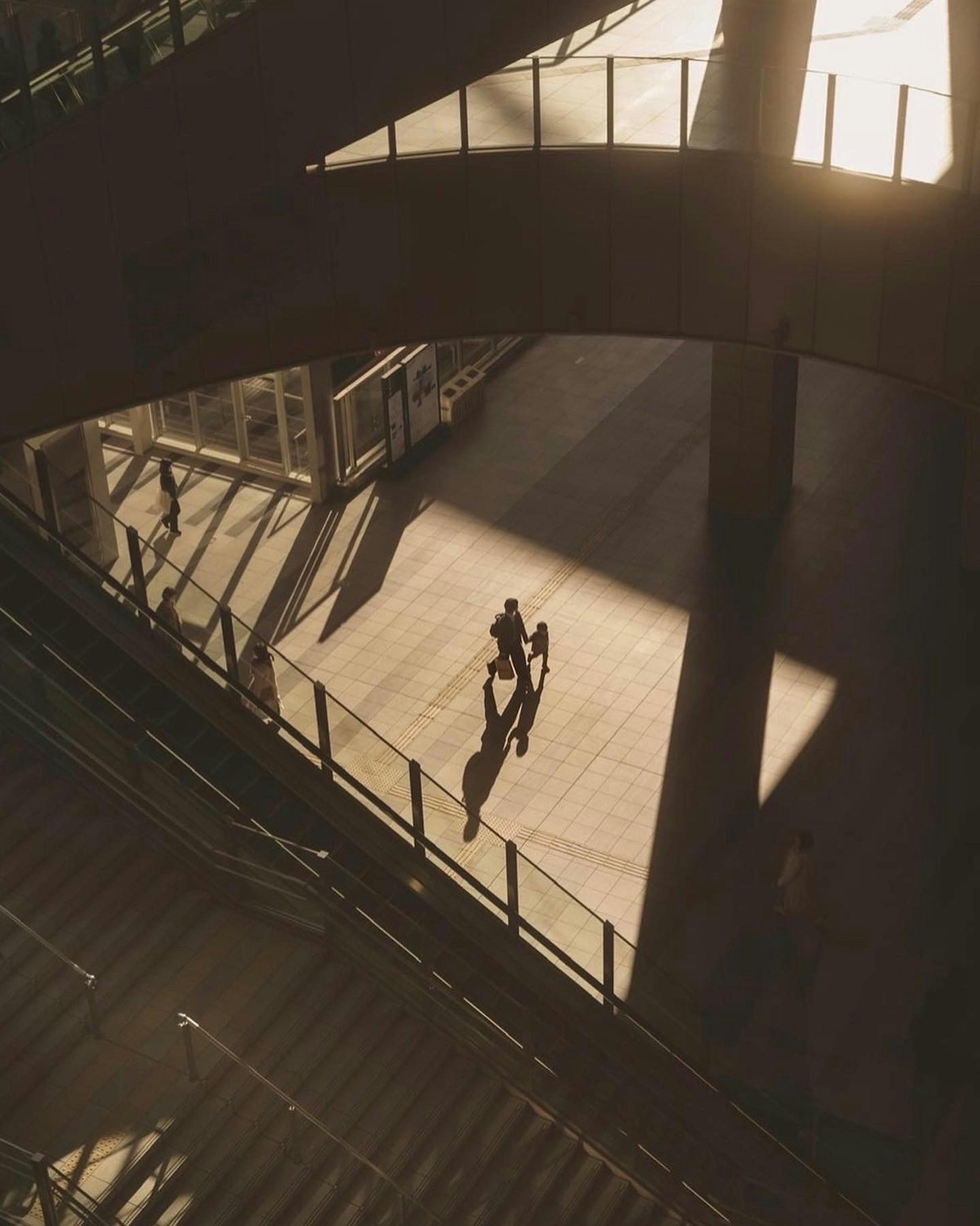 Image capturant des personnes marchant à l'intérieur d'un bâtiment au coucher du soleil