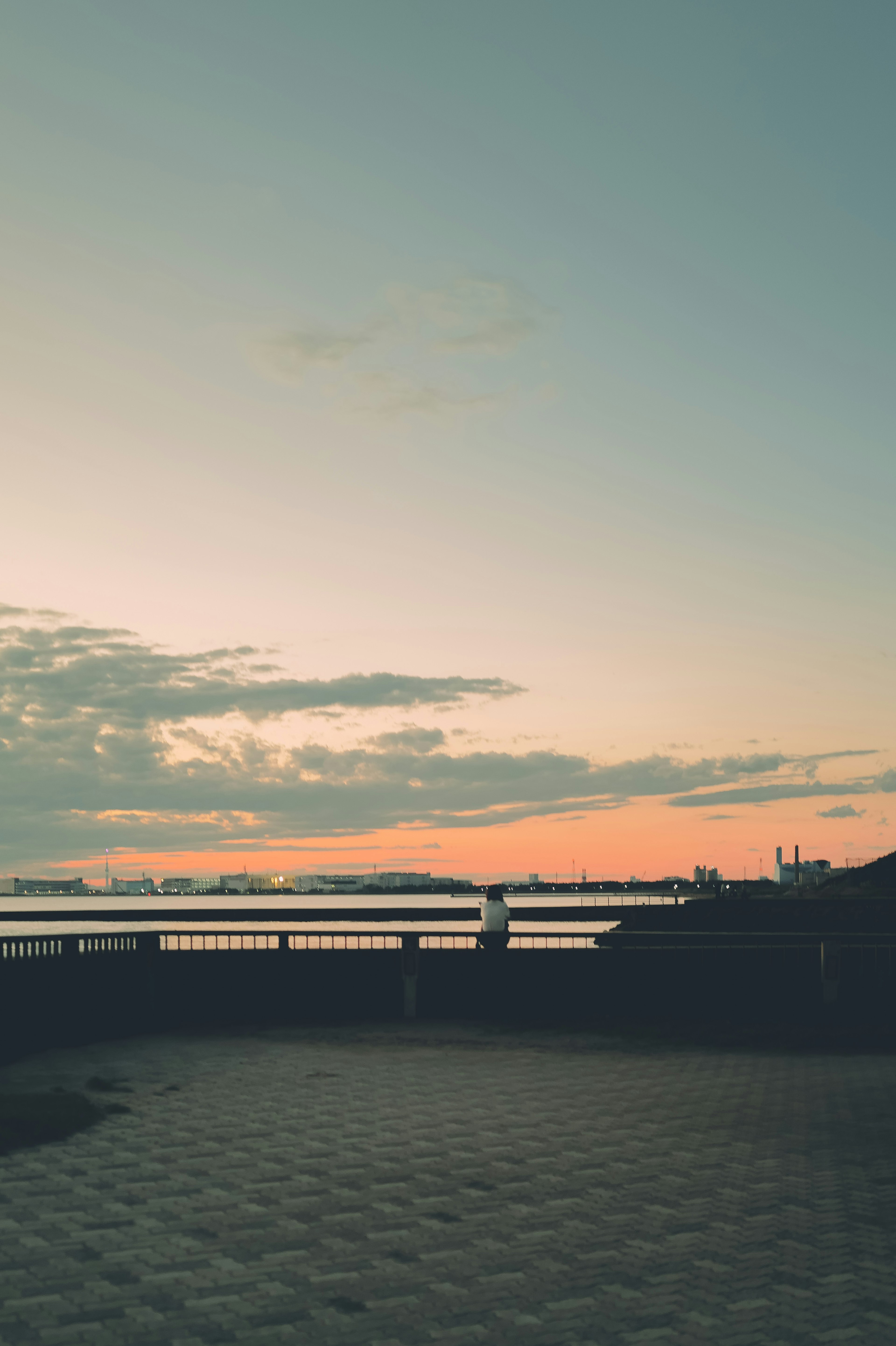 Scenic view of a sunset sky and water with a visible bridge in a tranquil setting