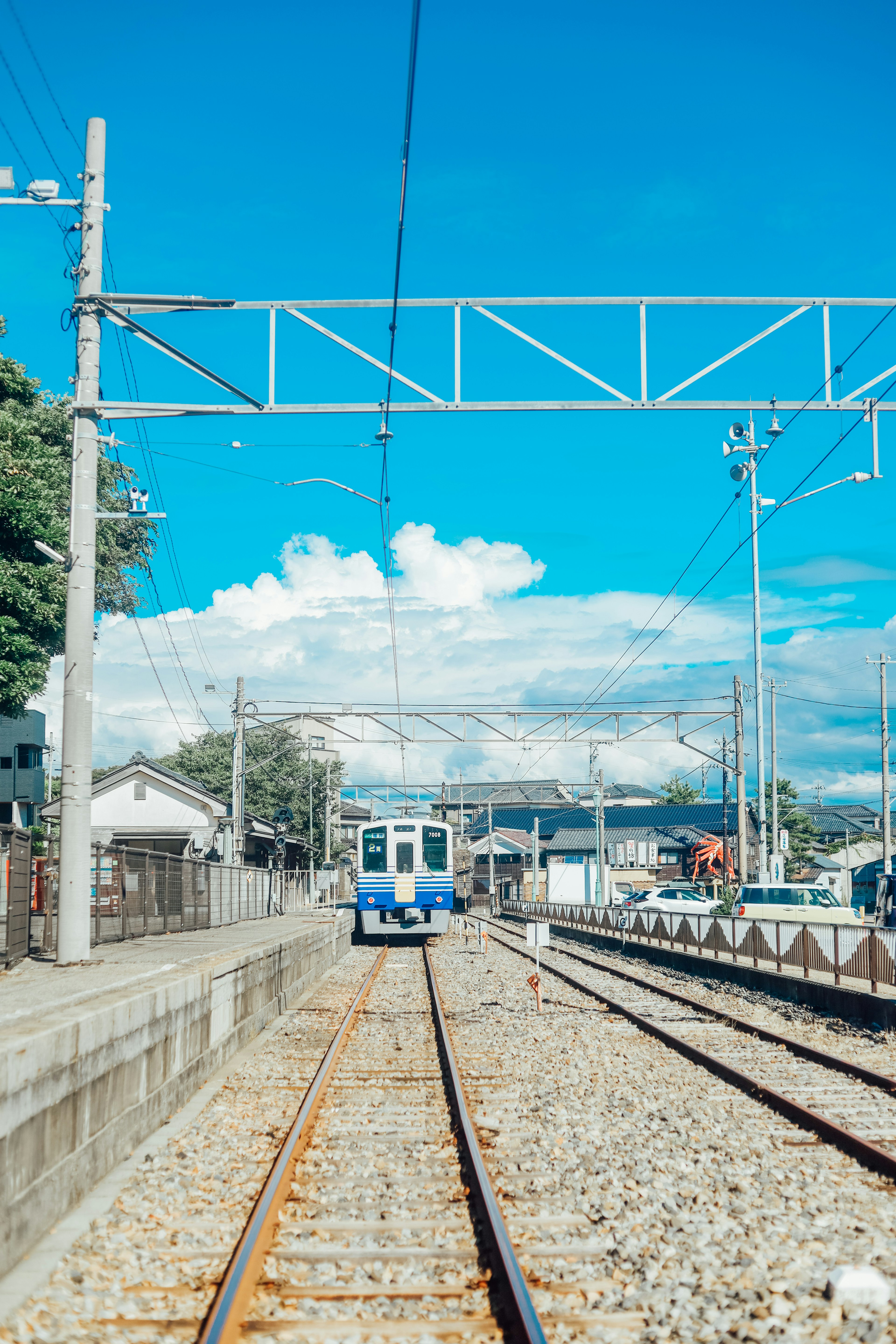 Scène de gare avec un train sous un ciel bleu clair