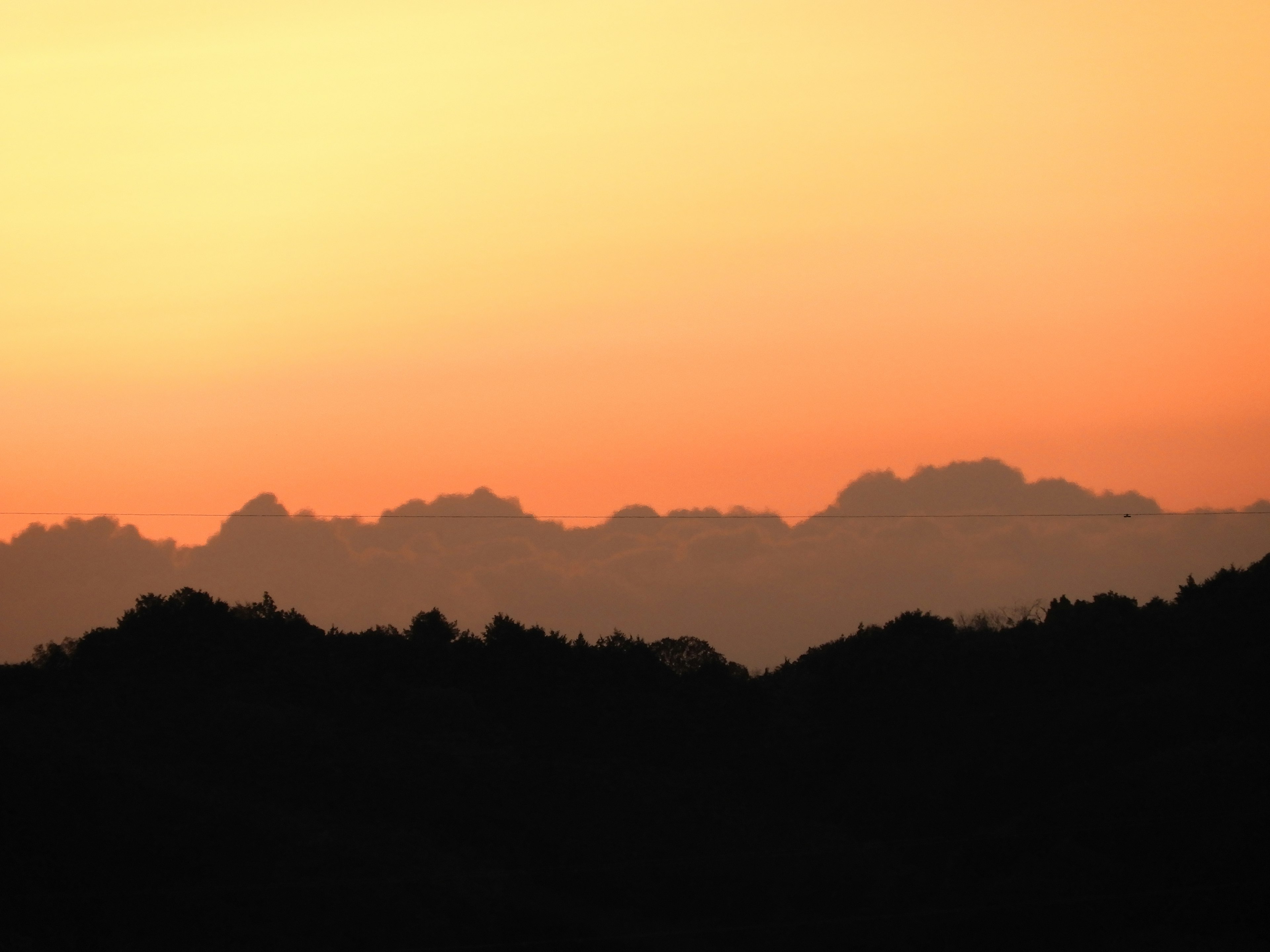 夕焼けの空にシルエットの山々が見える風景