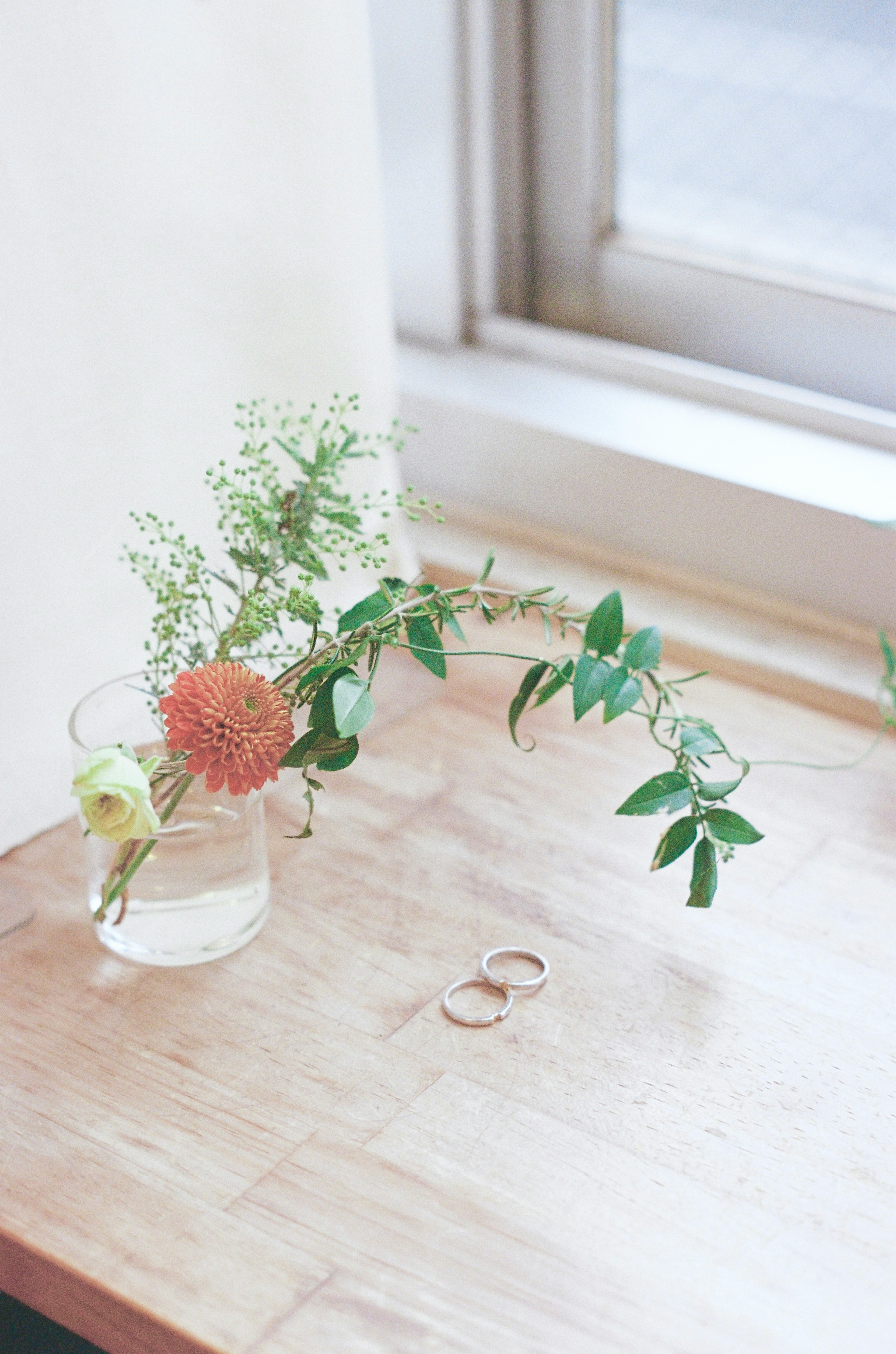 Stilllebenfoto von Blumen und Ringen auf einem Tisch