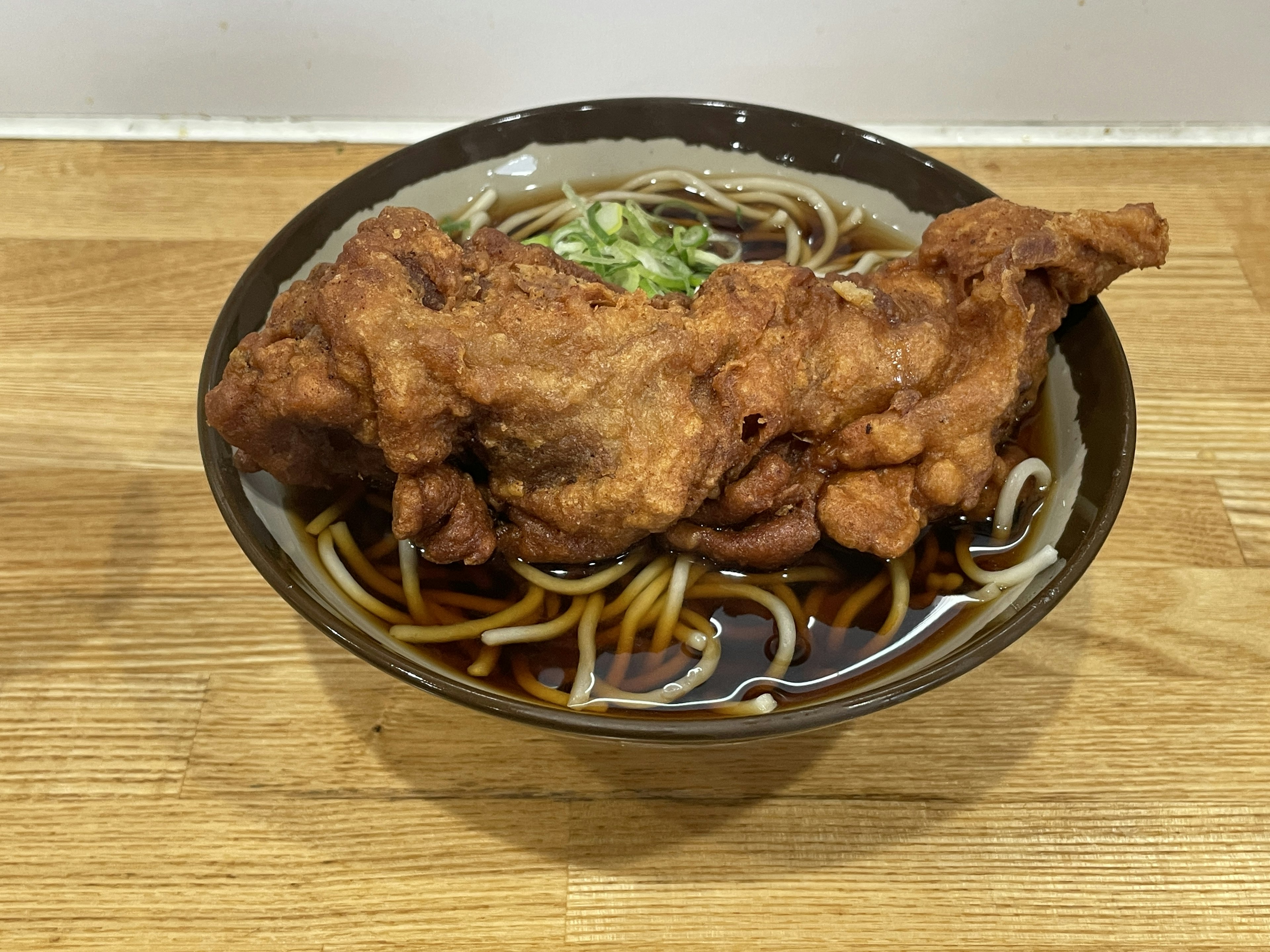 Bowl of soba noodles topped with large fried chicken