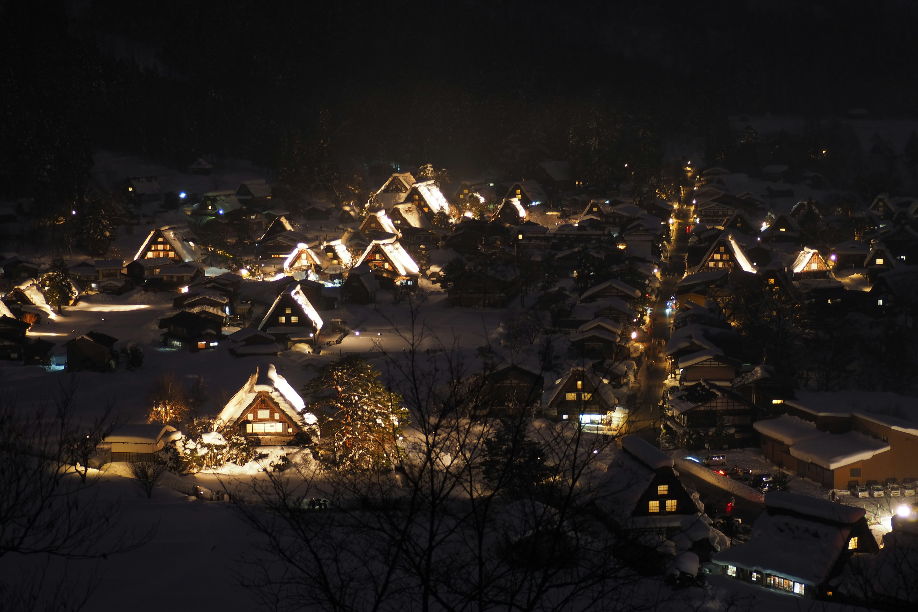 Vista notturna di un villaggio innevato con case illuminate